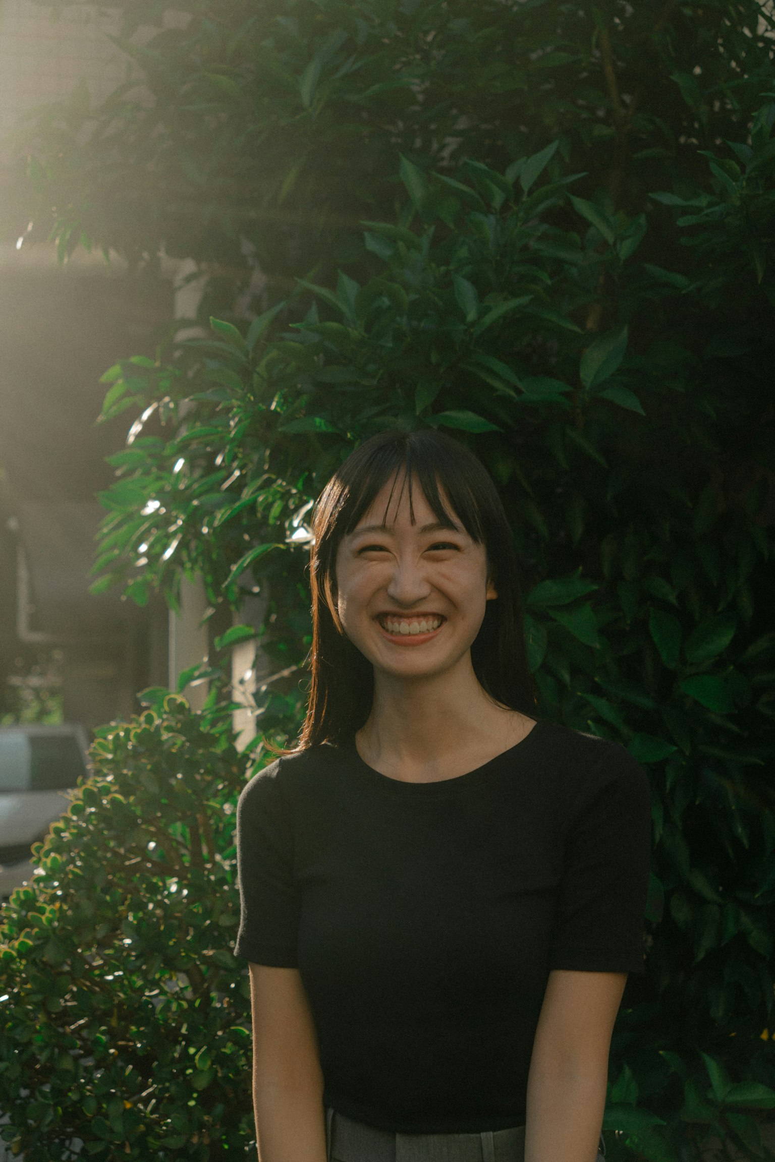 Ritratto di una donna sorridente davanti a fogliame verde