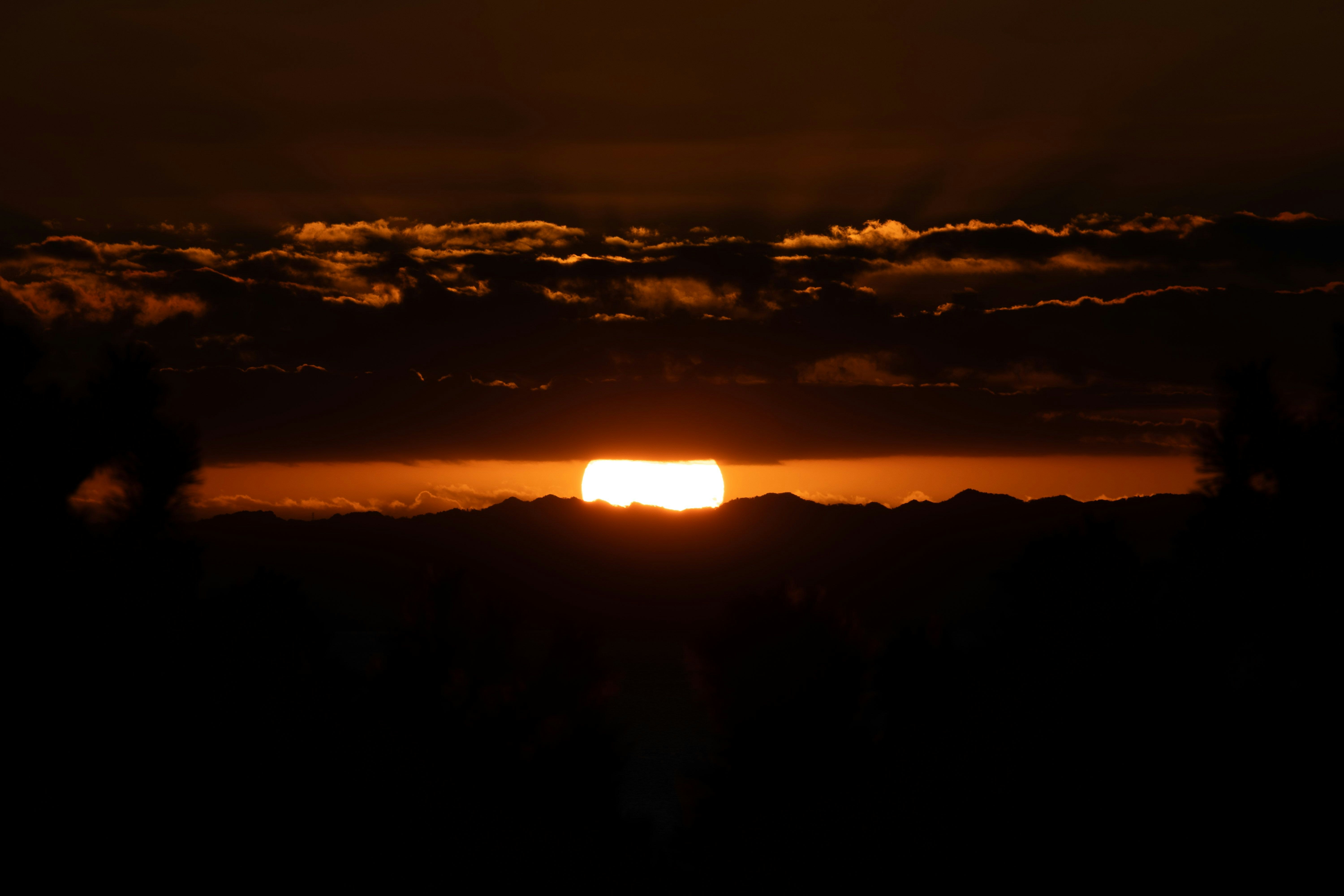 夕焼けの雲間から差す太陽の光