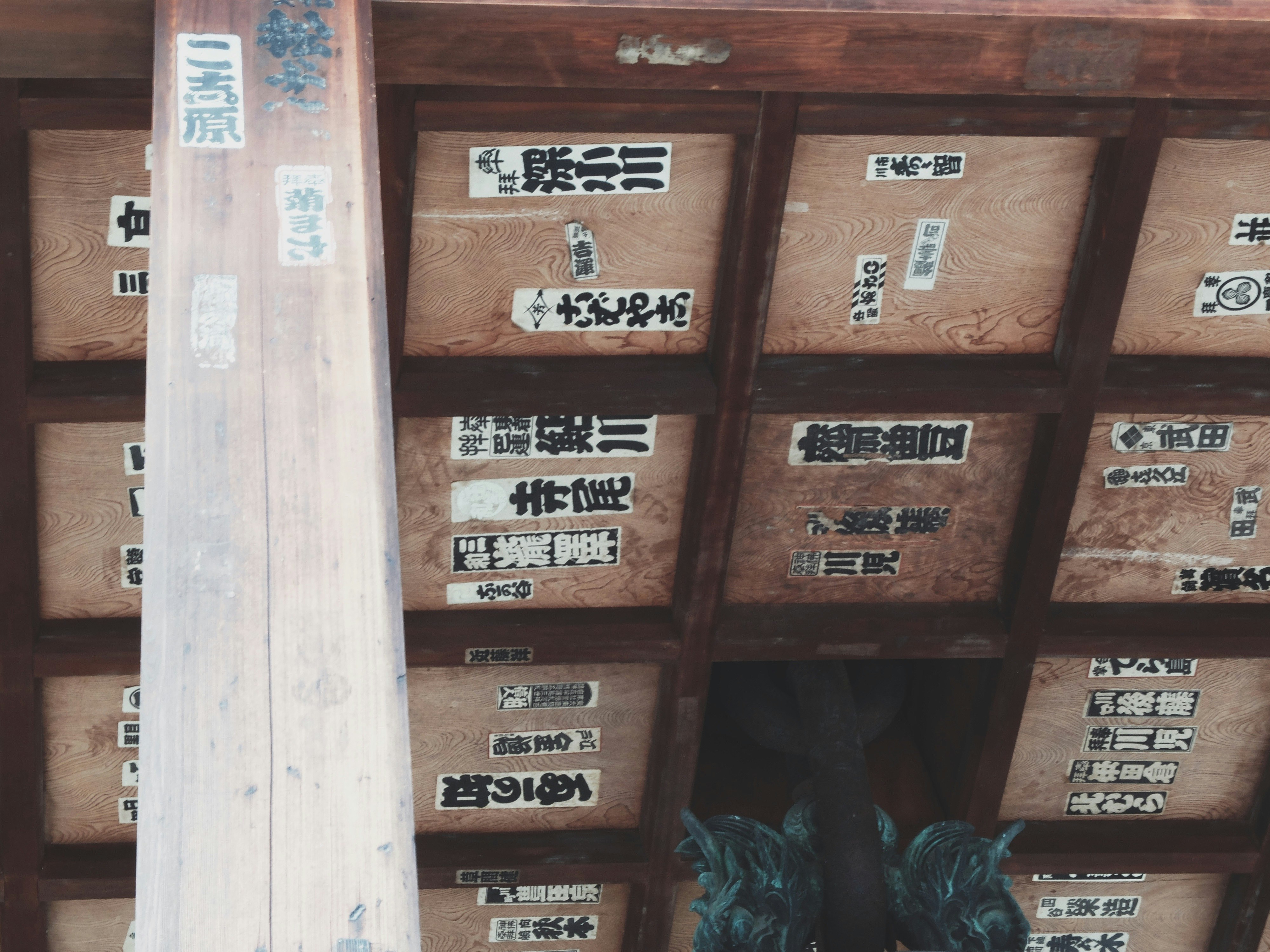 木製の棚に並ぶ千社札の札