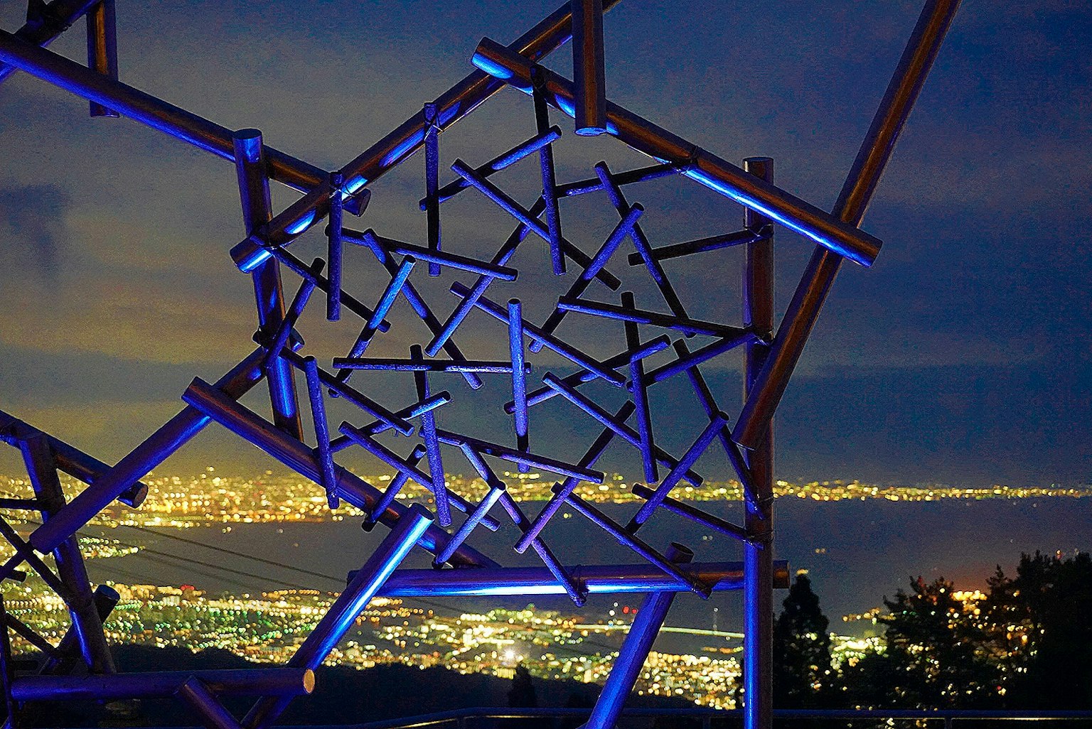 Structure moderne avec un éclairage bleu sur fond de ville nocturne
