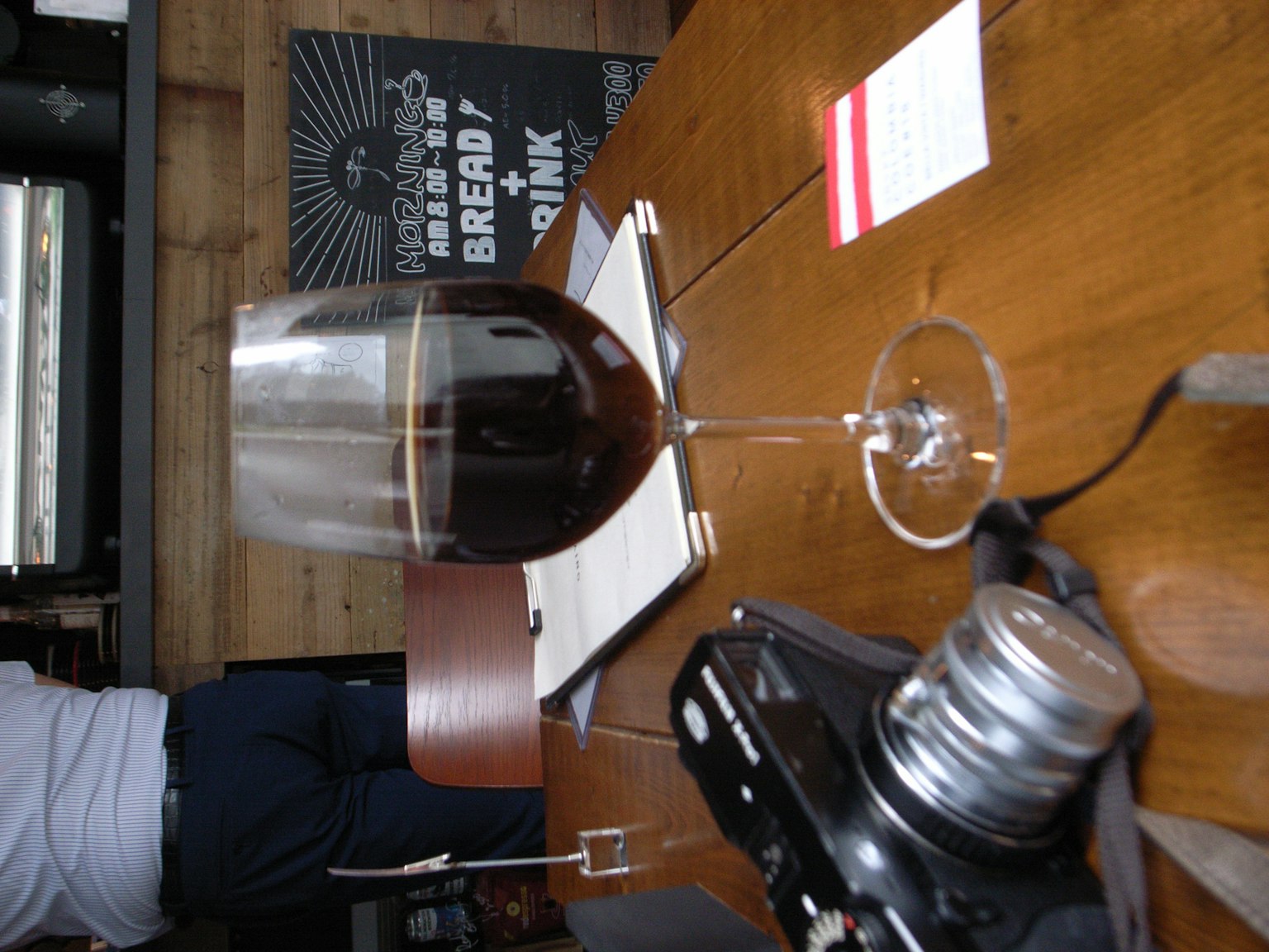 Une scène avec un verre de vin rouge et un appareil photo sur une table en bois