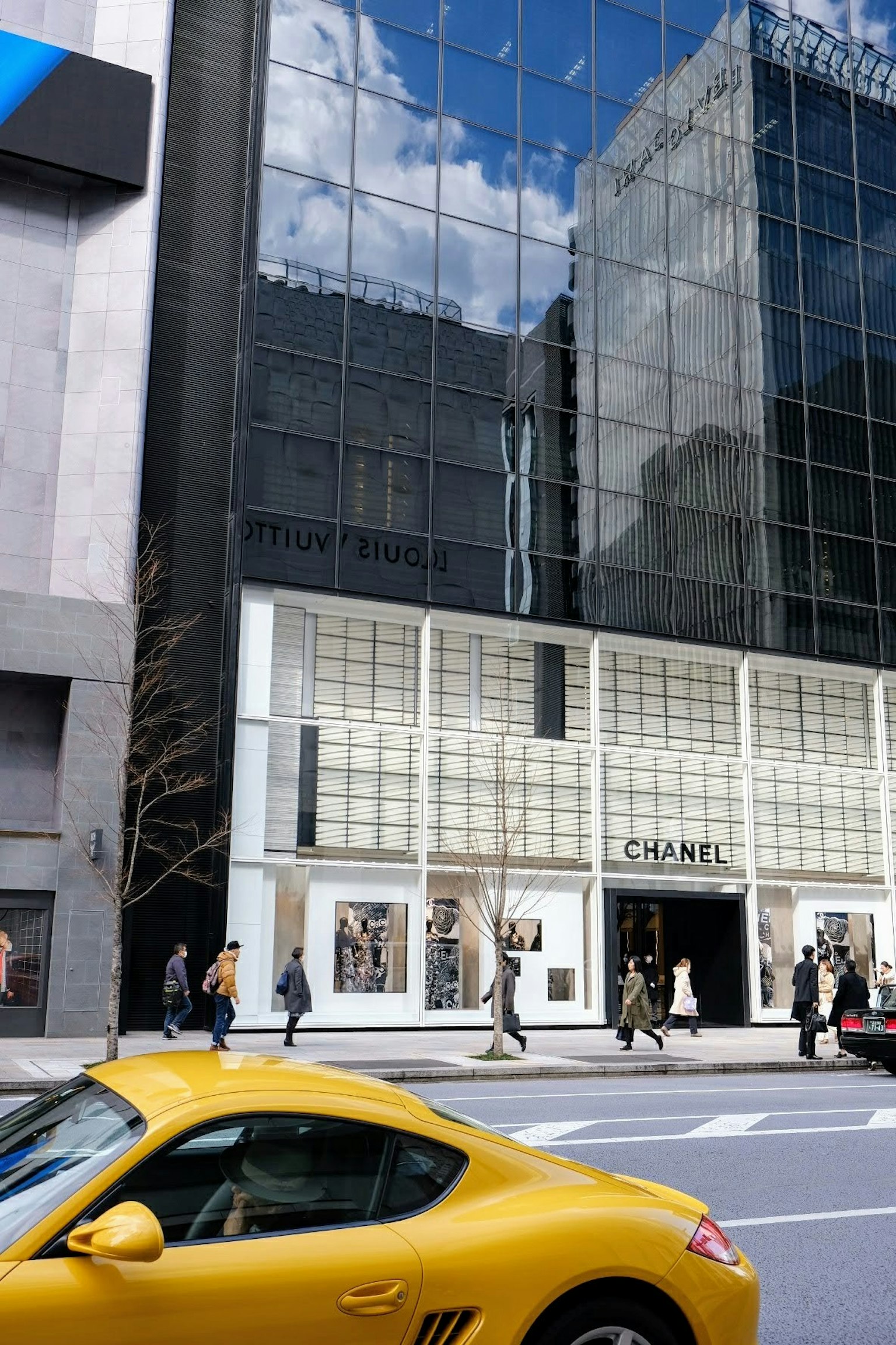Chanel store with glass facade and yellow car