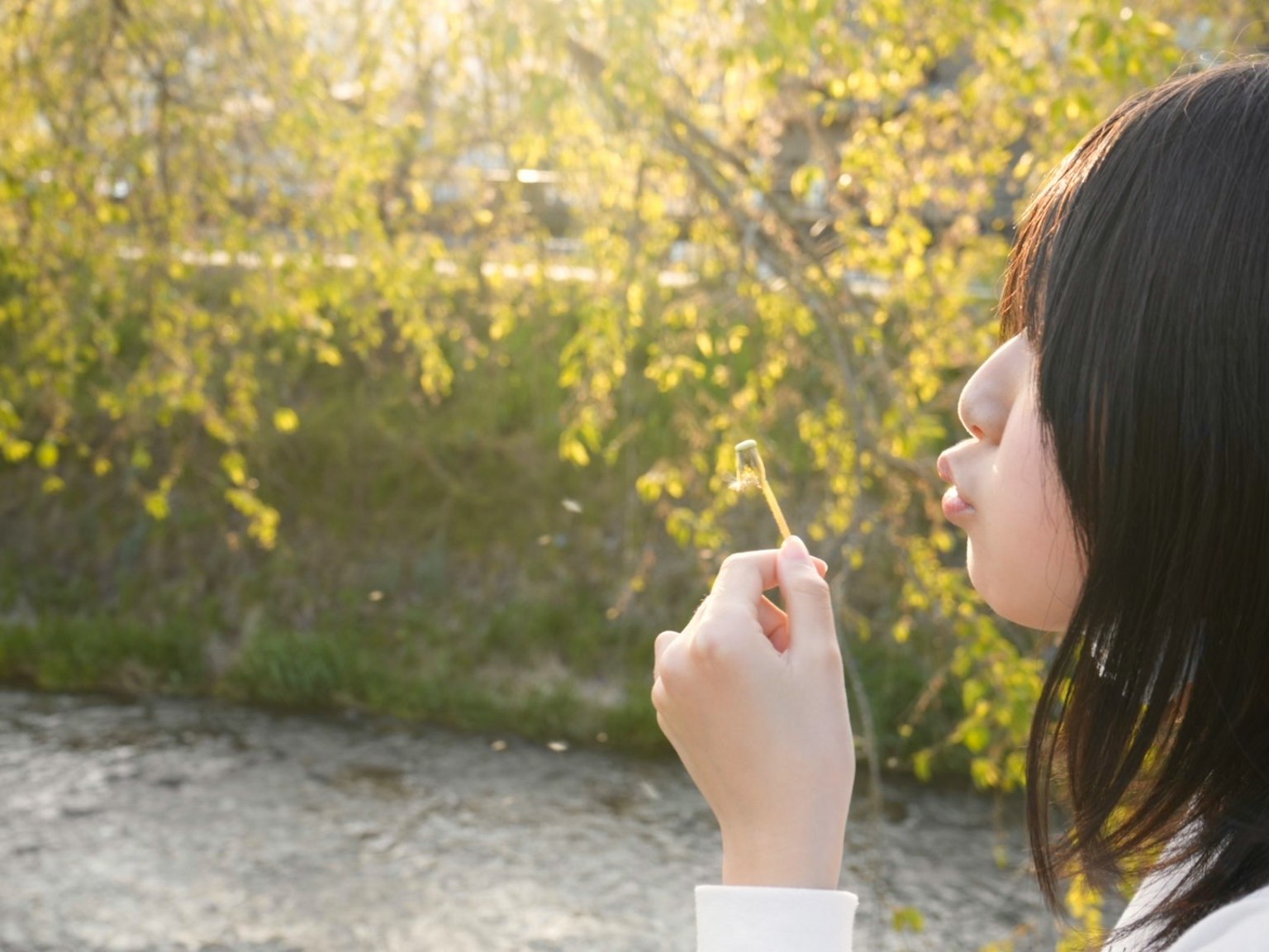 女孩在河边吹着棒子，背景是黄色的叶子