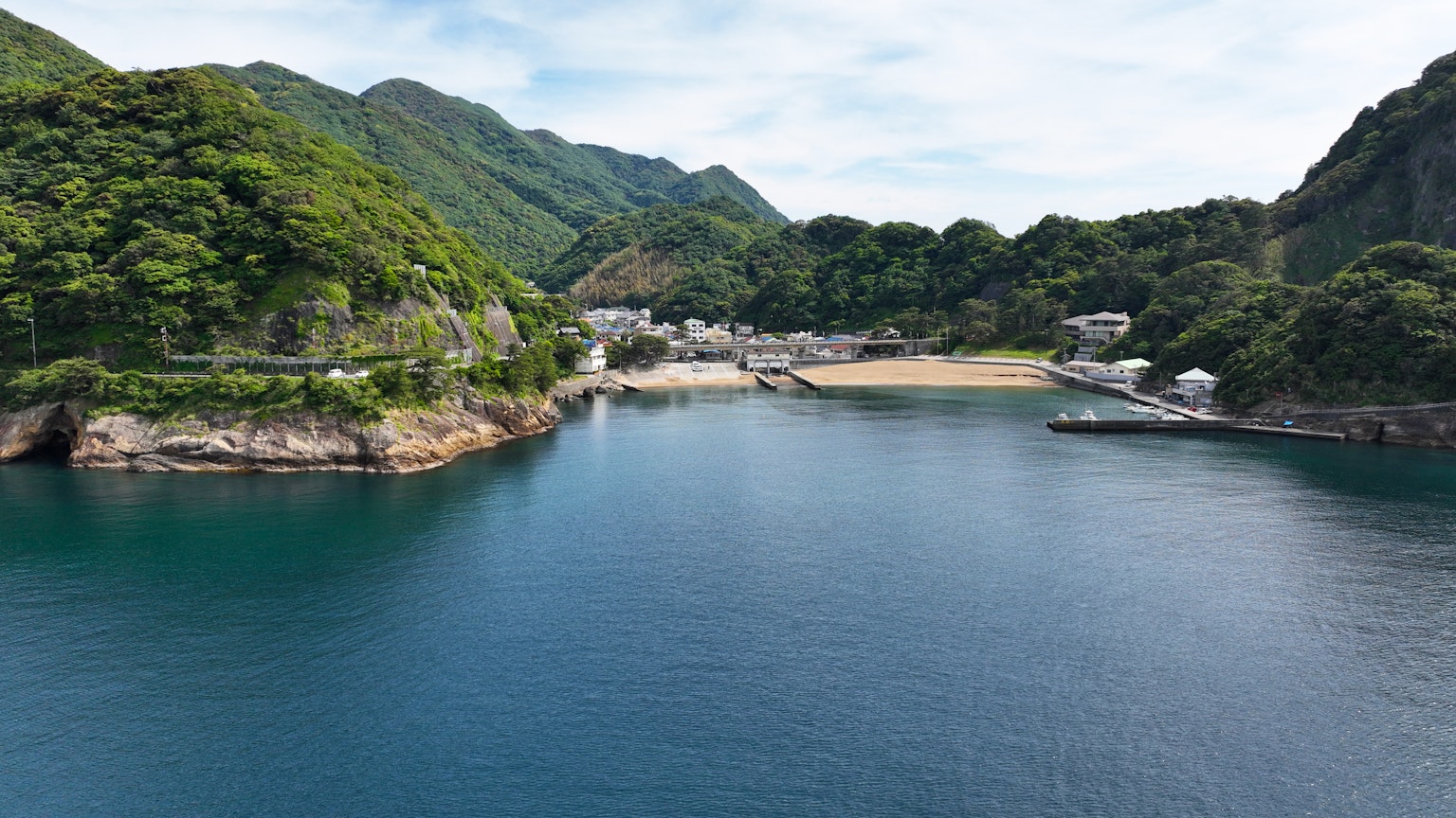 ทิวทัศน์ที่สวยงามของอ่าวสงบที่มีภูเขาเขียวขจีล้อมรอบ