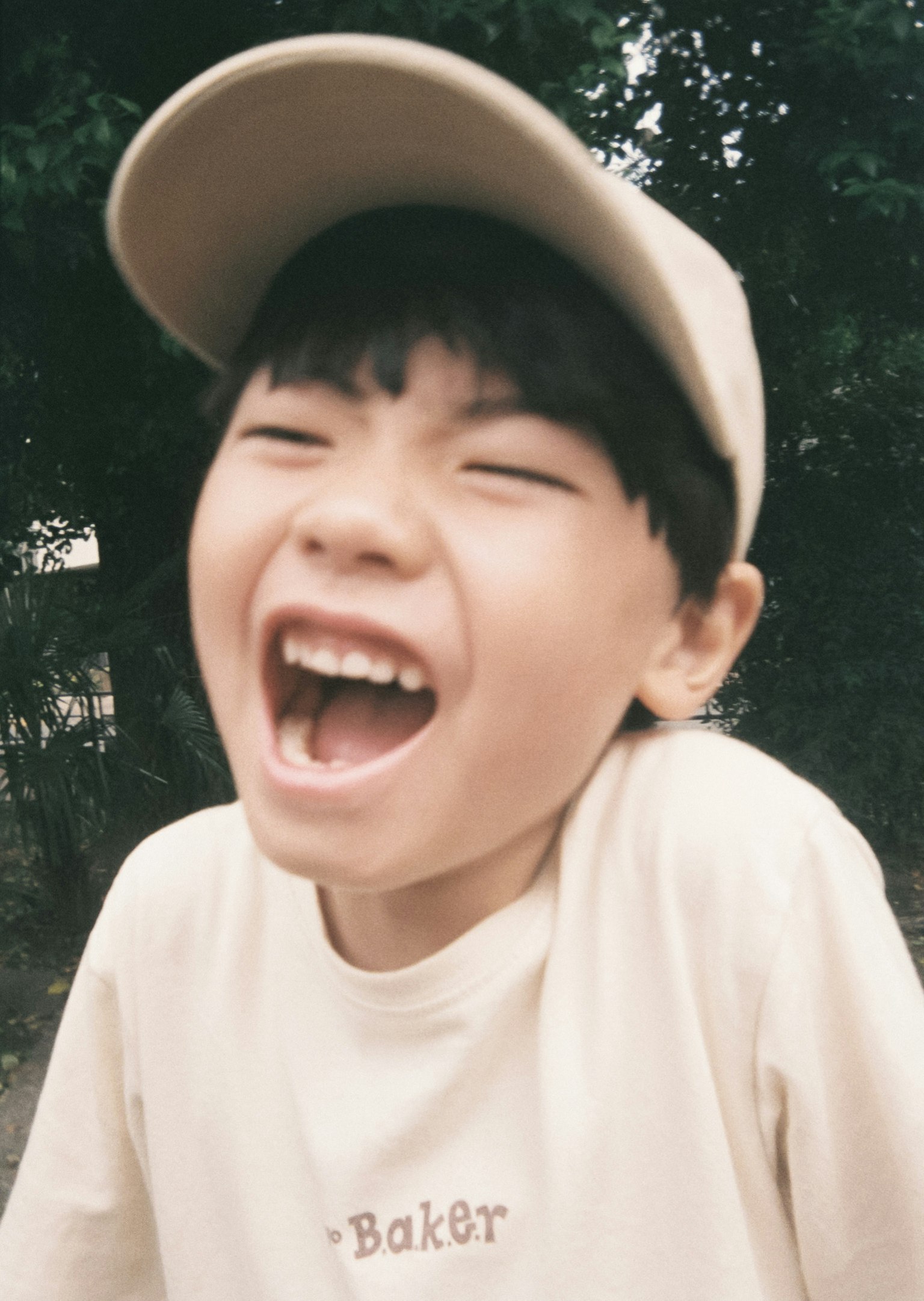 笑っている少年がキャップをかぶっている