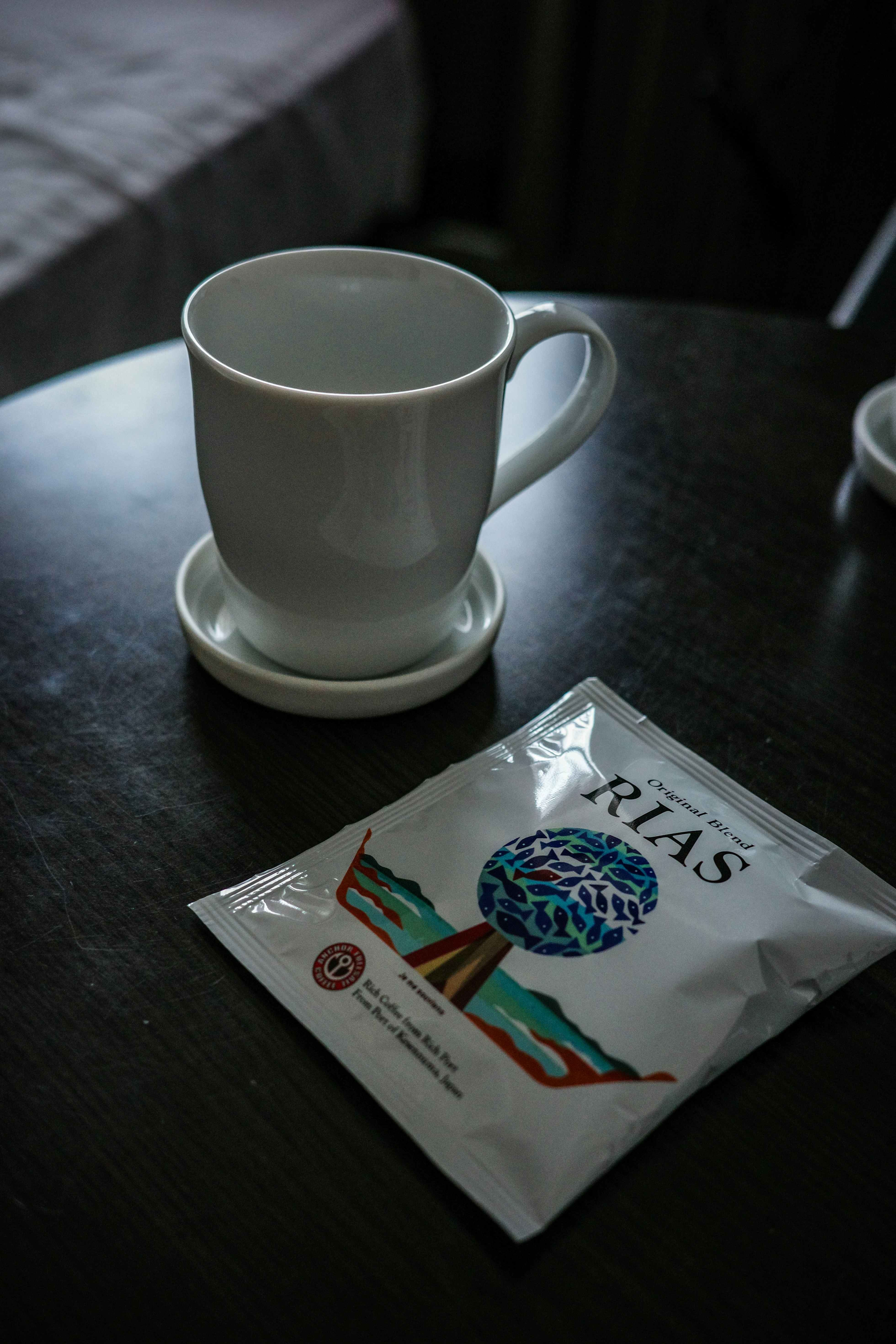 Una taza sobre una mesa con un paquete de granos de café