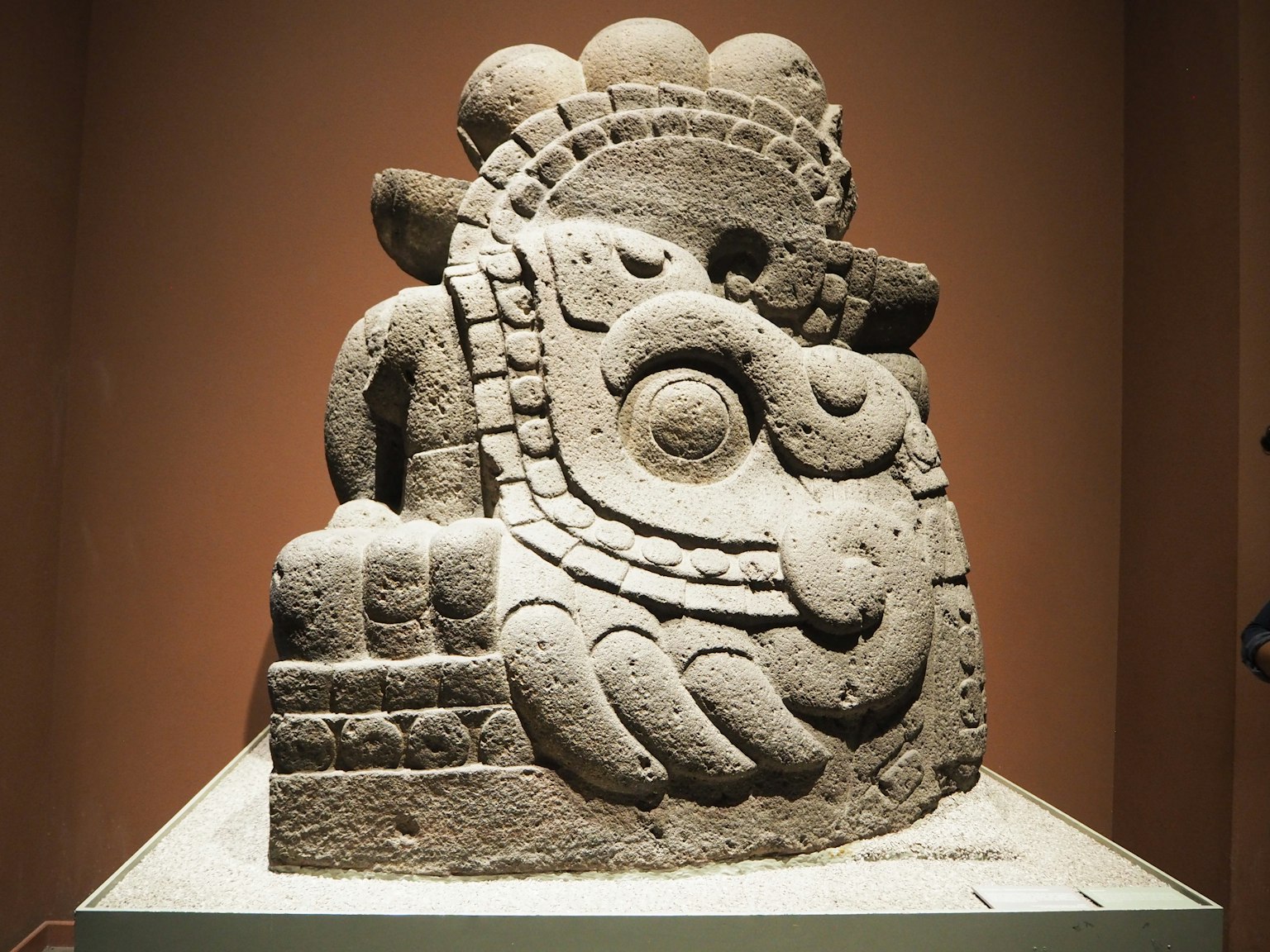 Cette sculpture représente une divinité ancienne avec un design unique et une décoration complexe