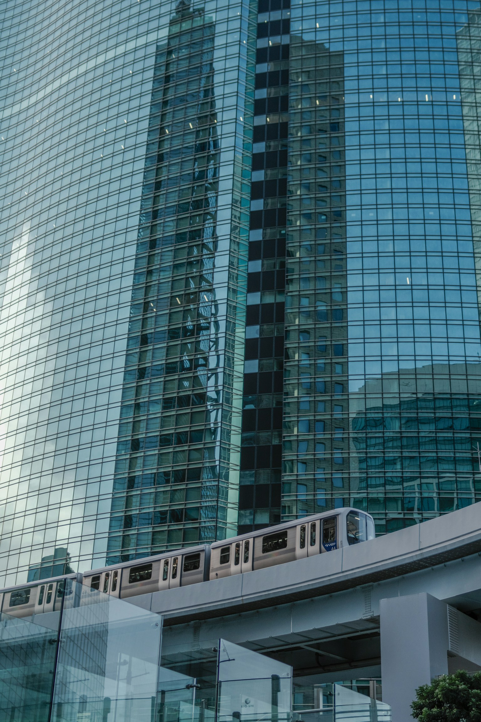Reflection of glass skyscrapers with a monorail passing