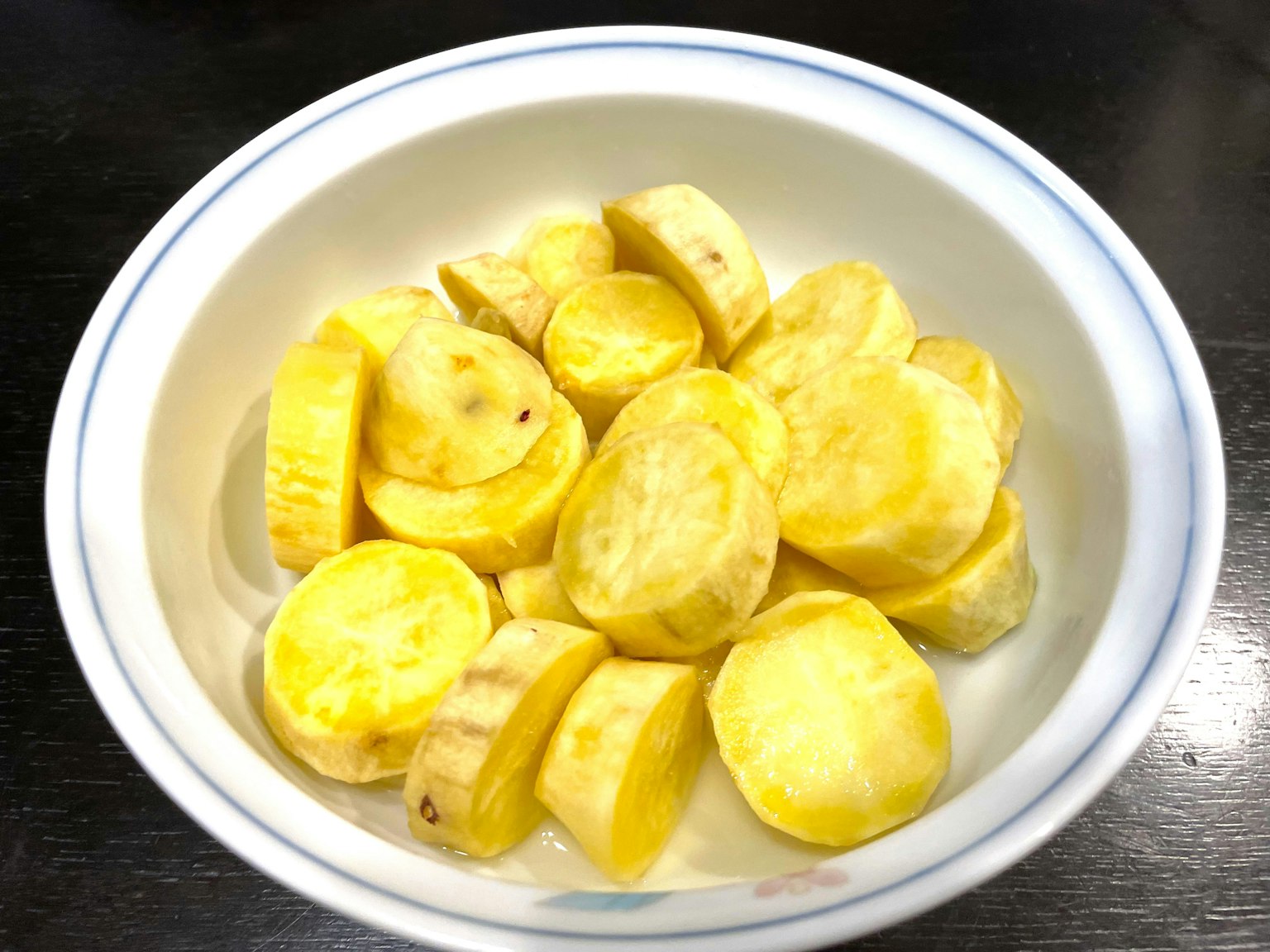 Tranches de patate douce jaune disposées dans un bol blanc