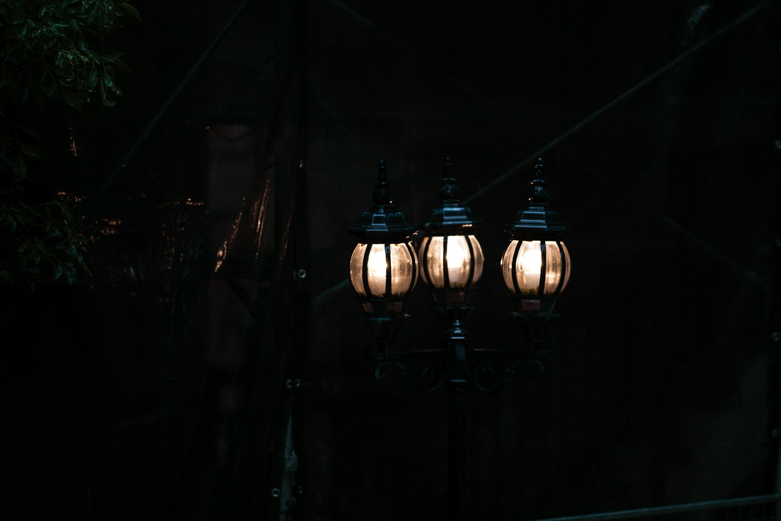 Drei Lampen, die sanft vor einem dunklen Hintergrund leuchten