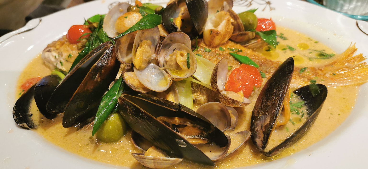 Piatto di frutti di mare con vongole e cozze accompagnato da verdure