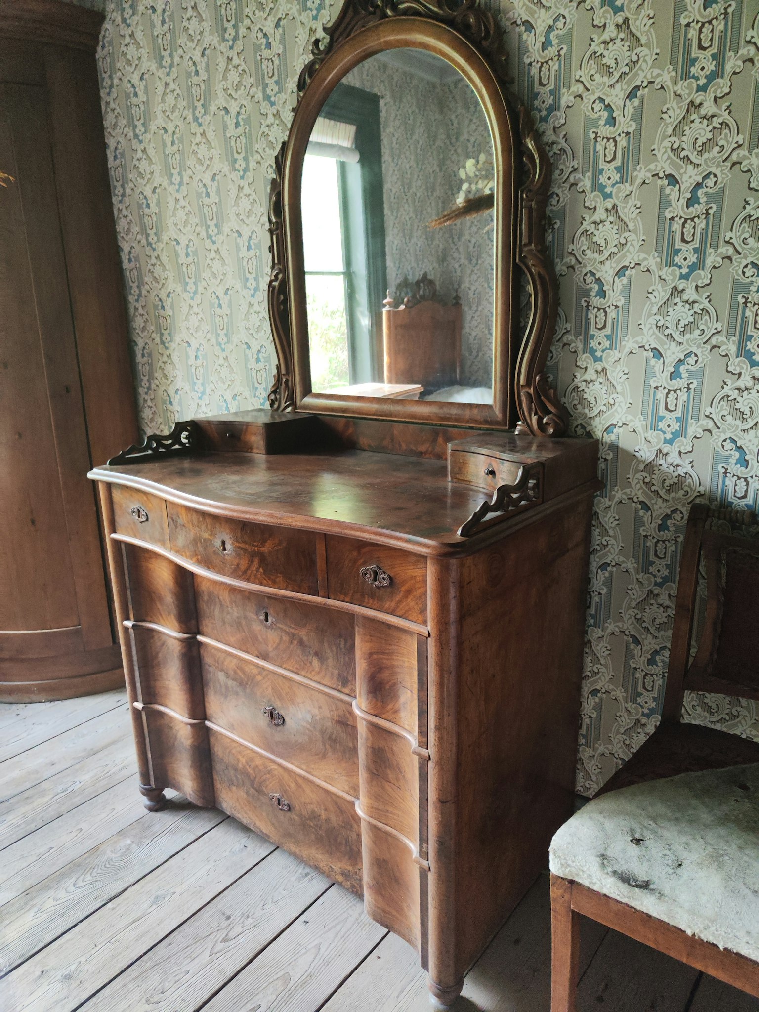 Antike Holzkommode mit großem Spiegel in einem Vintage-Raum
