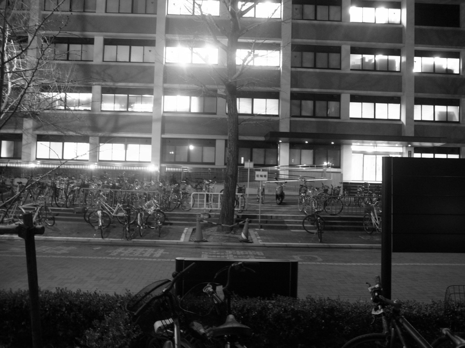 Paysage urbain nocturne avec des rangées de vélos et des lumières de bâtiments