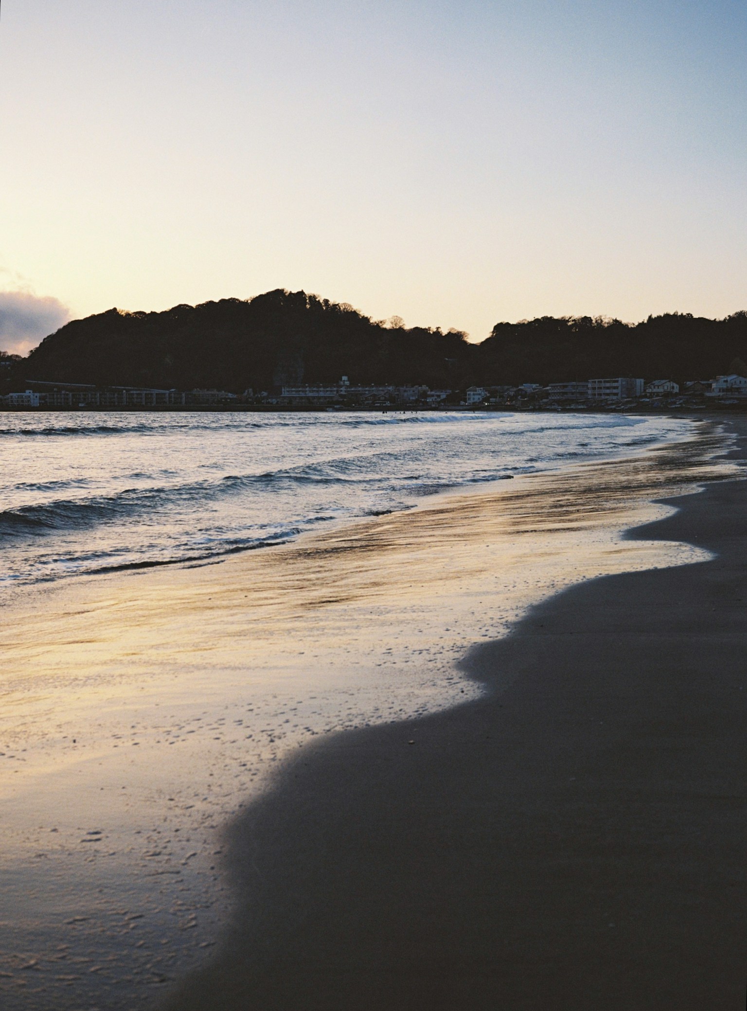 Garis pantai saat senja dengan gelombang lembut