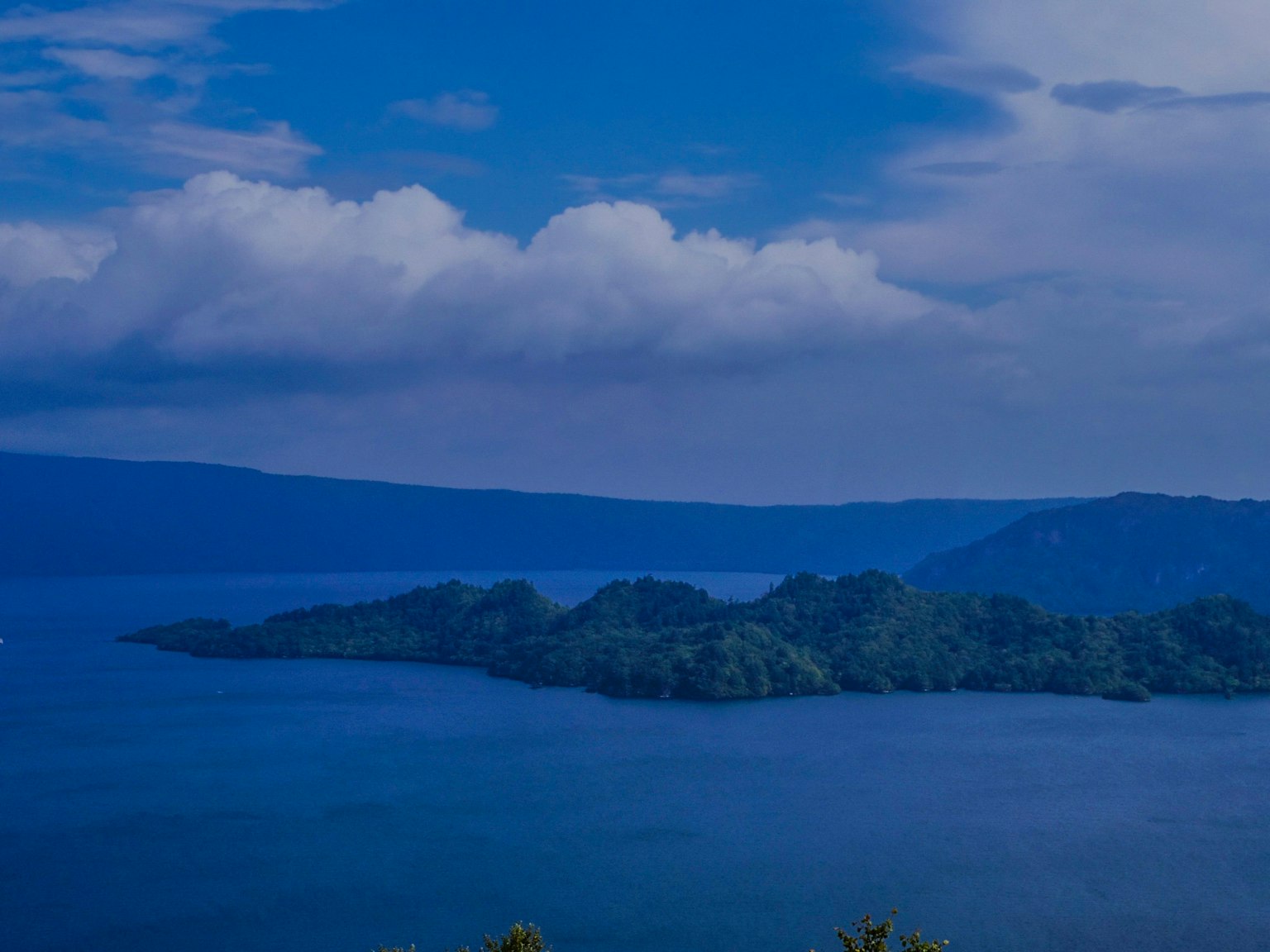 Malersicher Blick auf einen blauen See mit Inseln und bewölktem Himmel