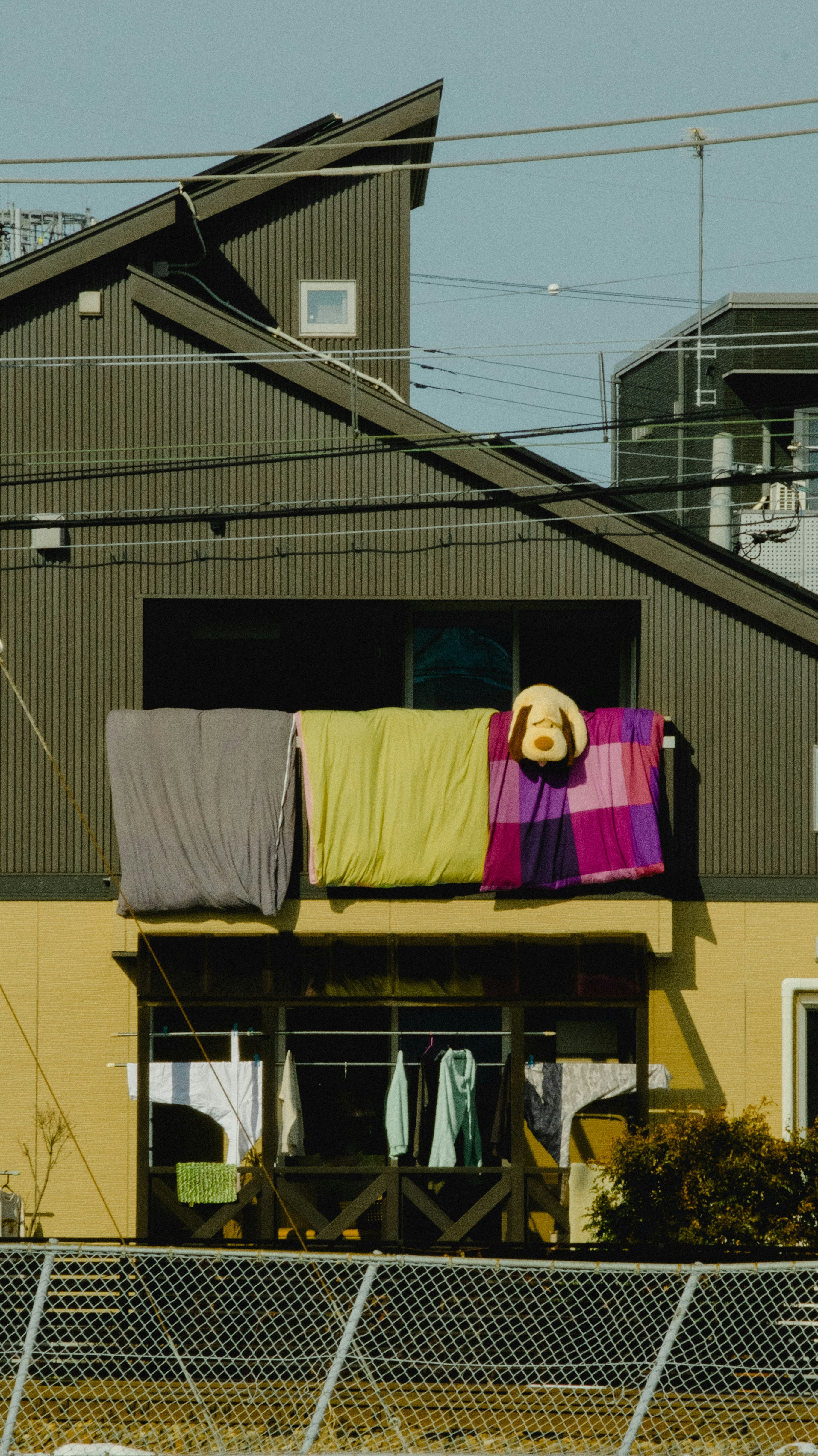 洗濯物が干された住宅のベランダと家々の外観