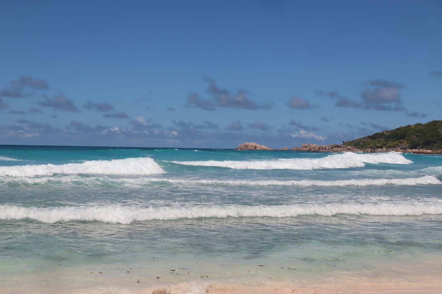 Vue pittoresque de la plage avec océan bleu et vagues blanches