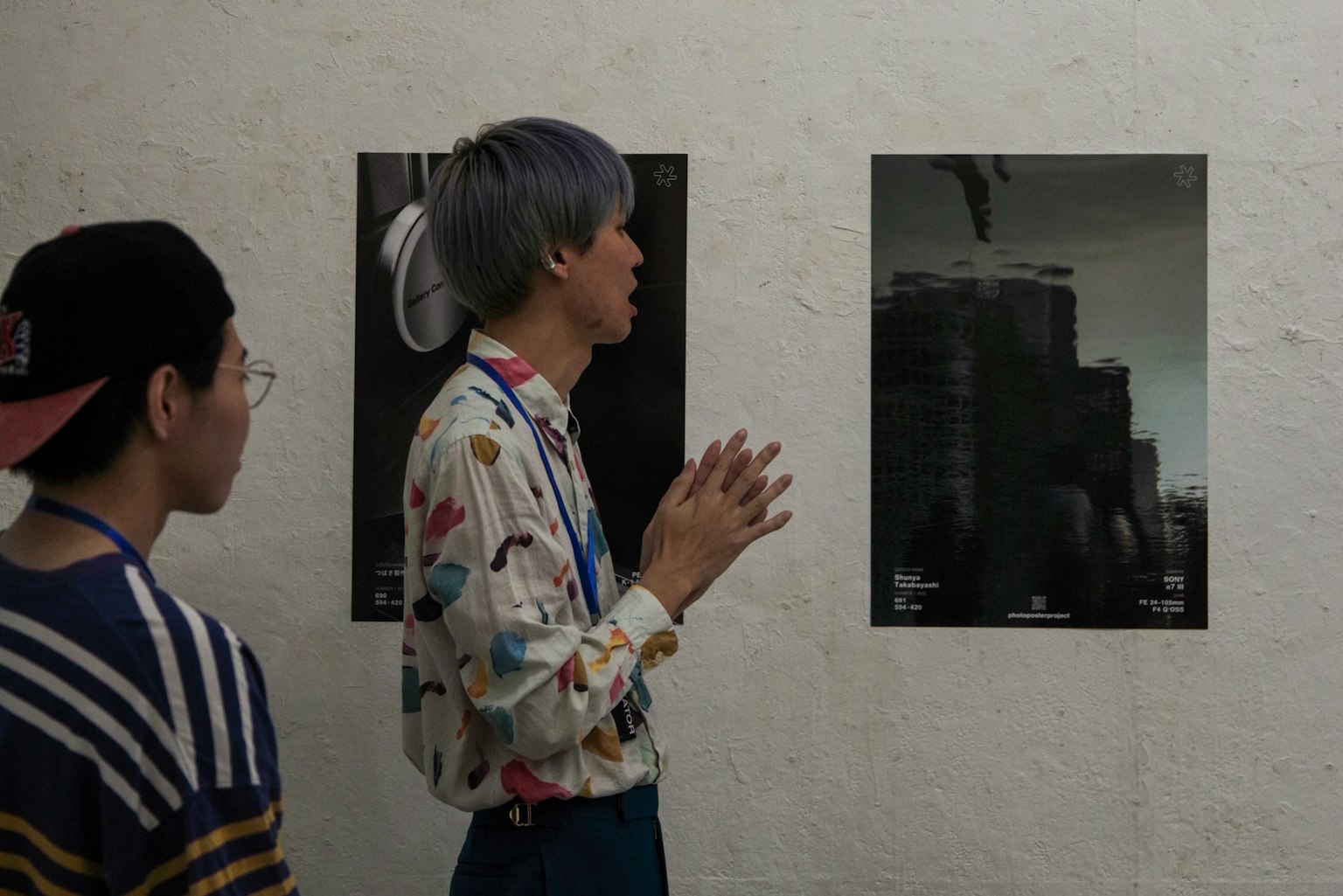 Two young people observing posters in an art gallery