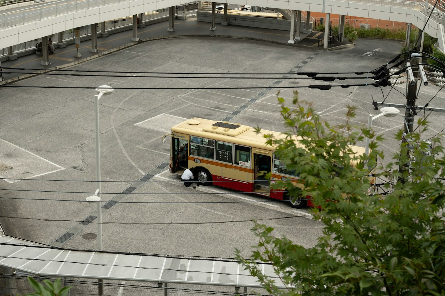 Un autobús estacionado en un terreno vacío con infraestructura circundante