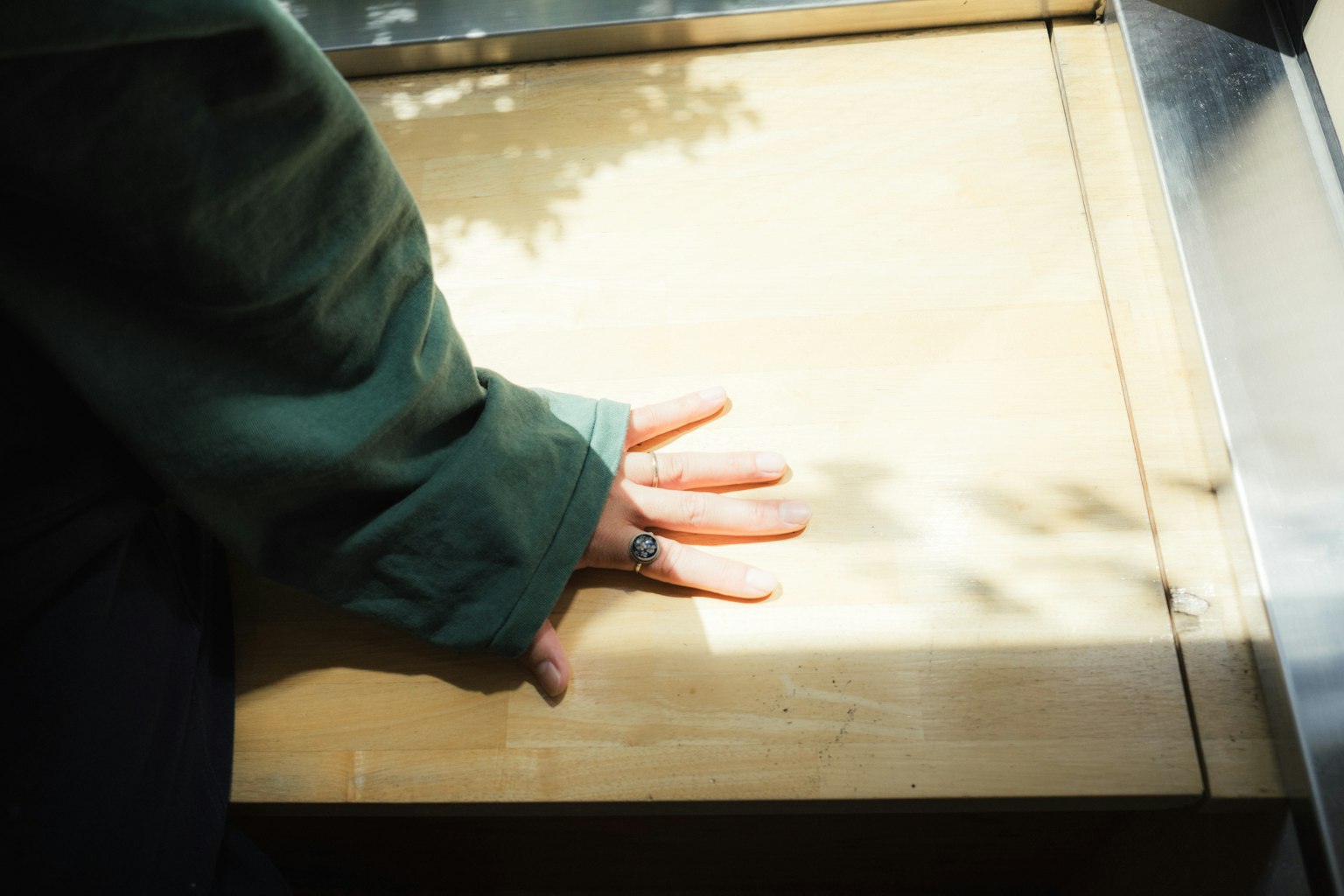 Una mano appoggiata su una superficie di tavolo in legno