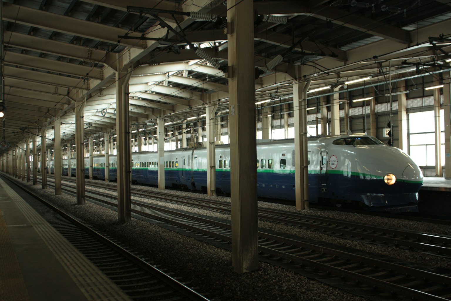 รถไฟชินคันเซ็นสีน้ำเงินและสีขาวจอดอยู่ที่ชานชาลา