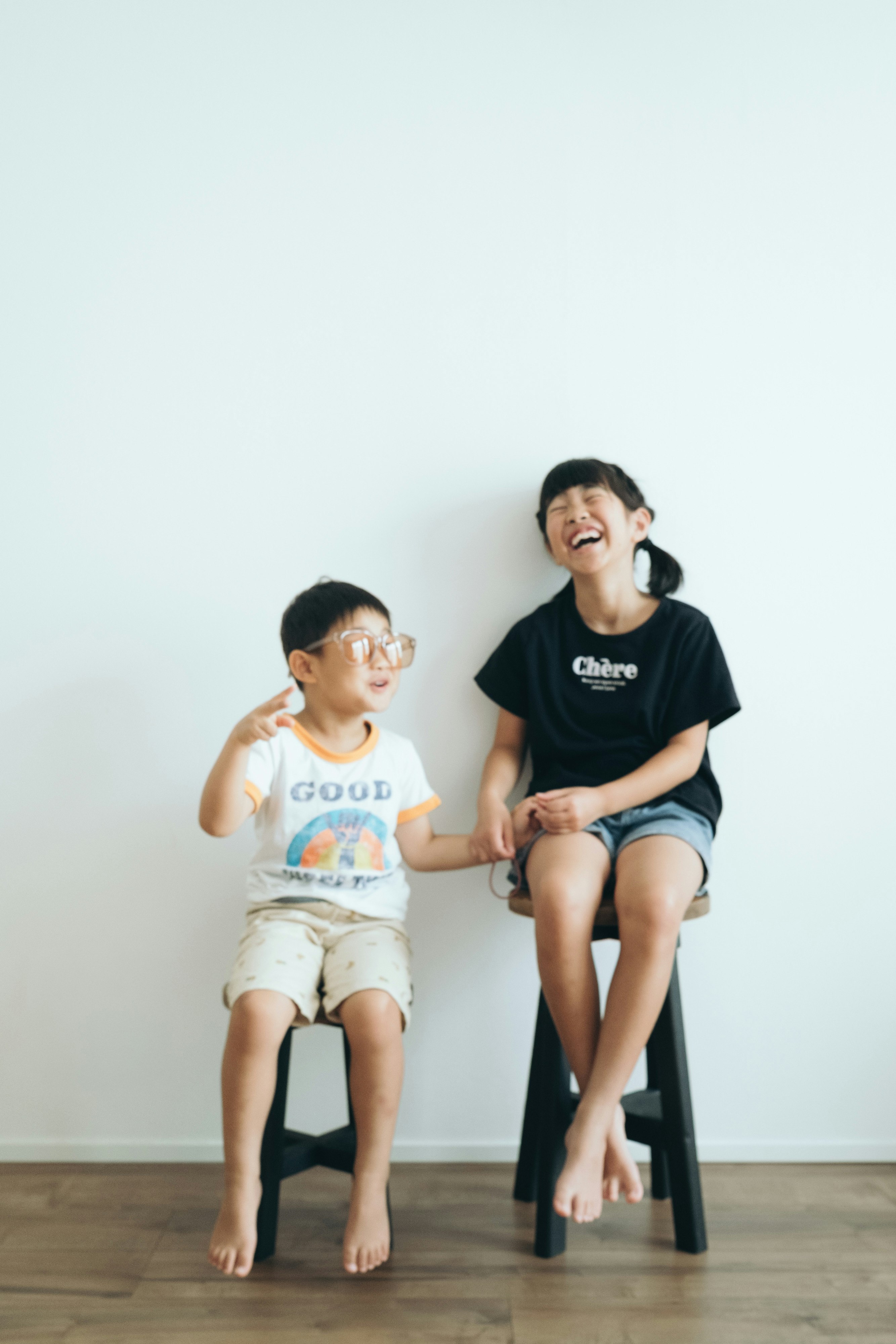 白い壁の前で座る母と子の親子