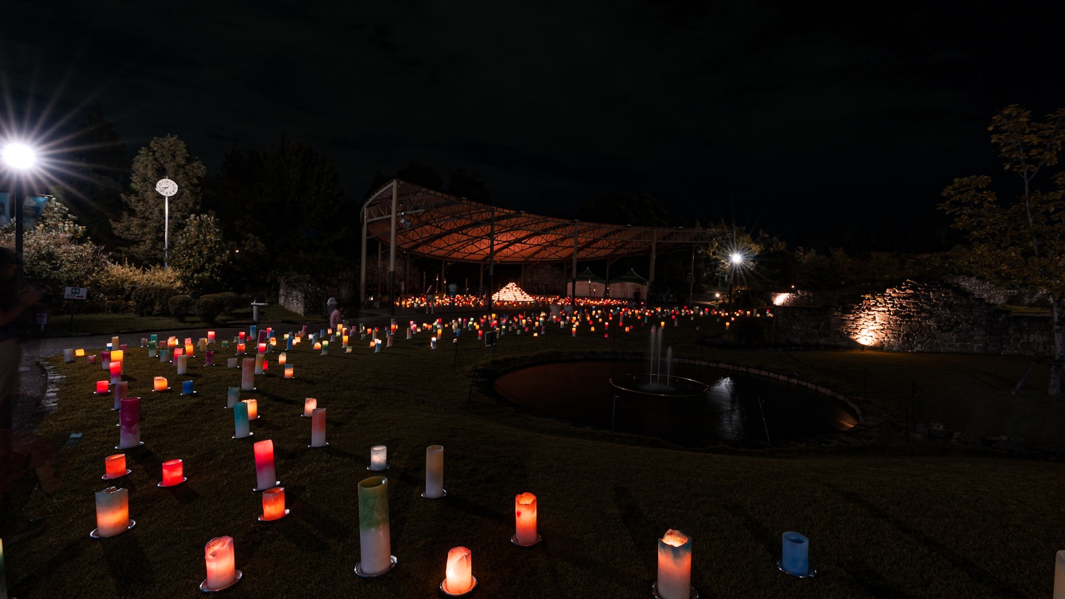 Bunte Kerzen in einem Park bei Nacht angeordnet