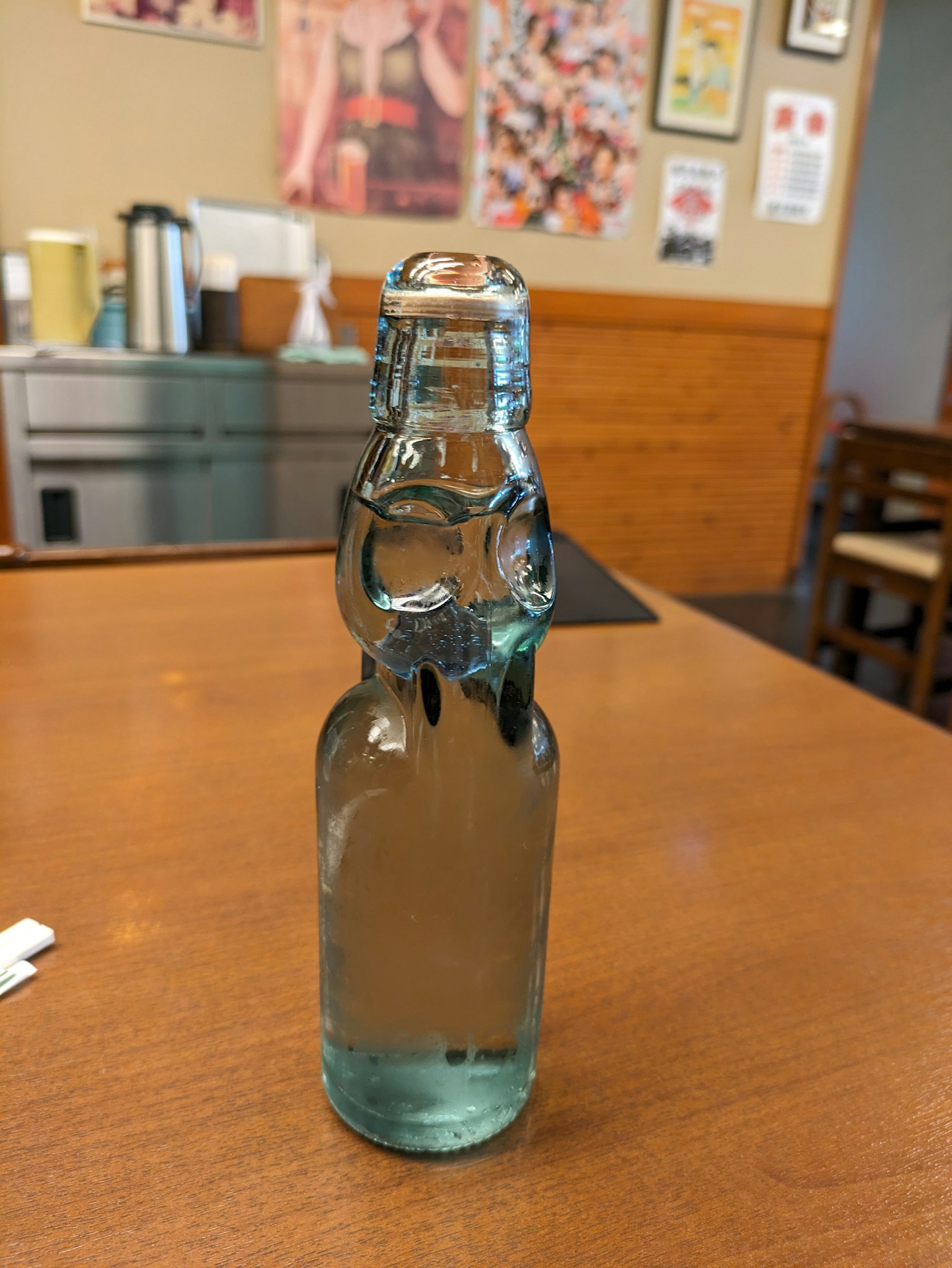 Una bottiglia di soda in vetro blu posata su un tavolo di legno