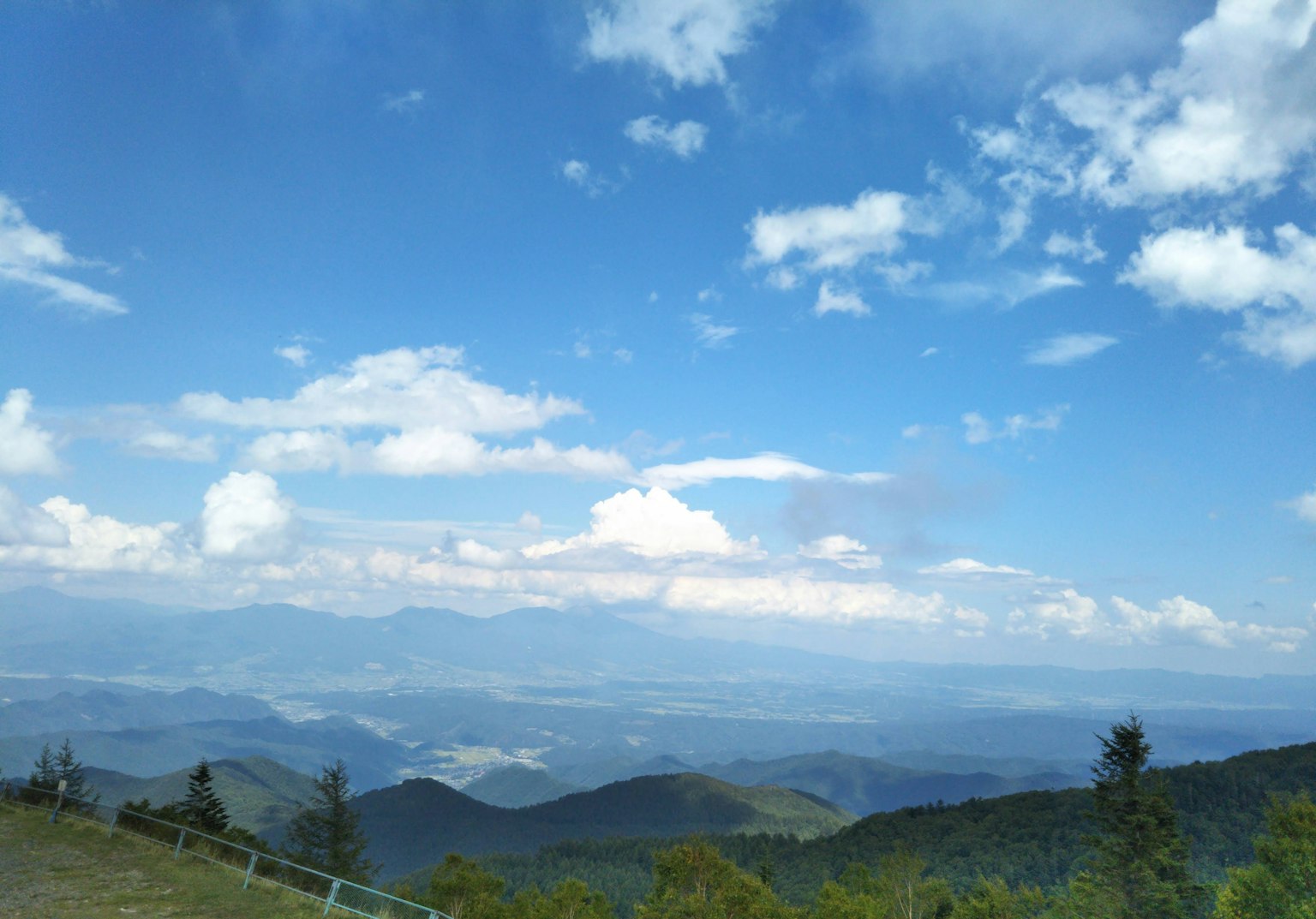 Scenic view of mountains under a blue sky with white clouds