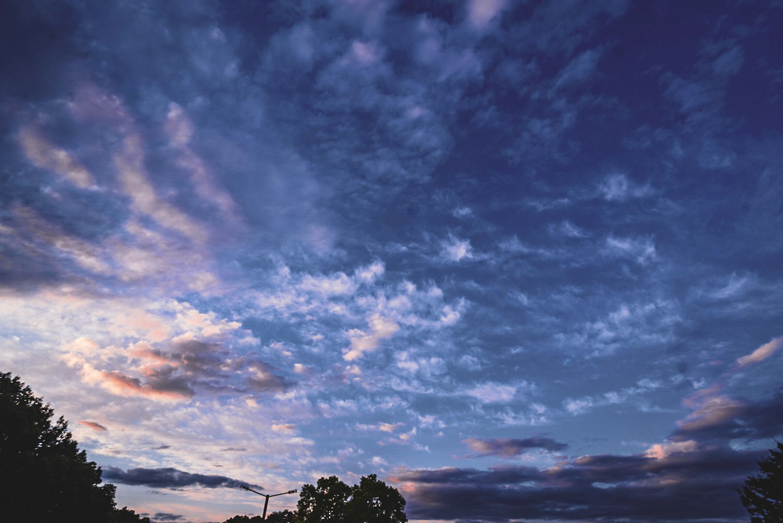 Vibrant sky filled with clouds in shades of blue and purple during sunset