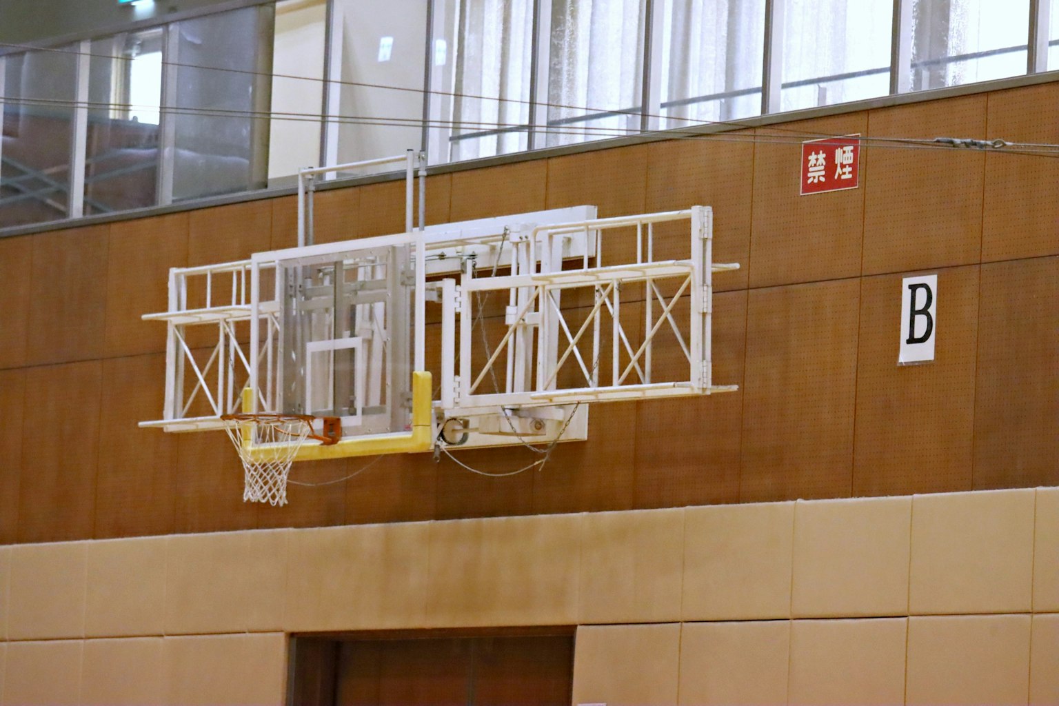 Panier de basket et panneau arrière montés sur un mur de gymnase