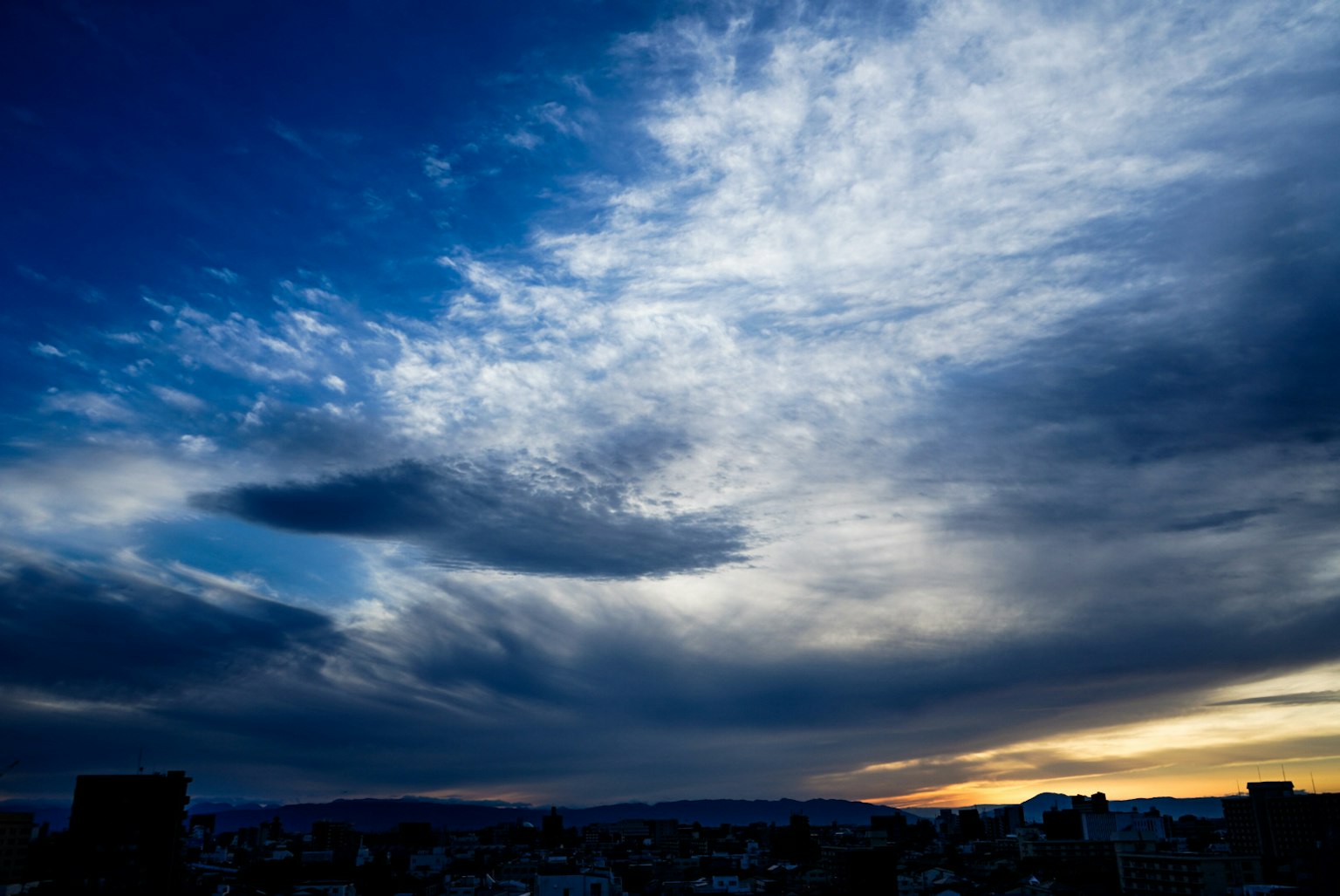 Dramatic sunset sky with blue and wispy clouds