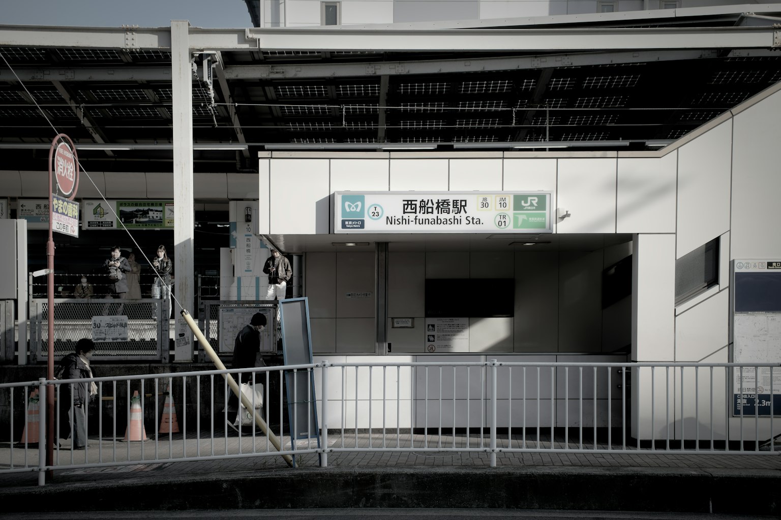 Entrée d'une gare avec des passants