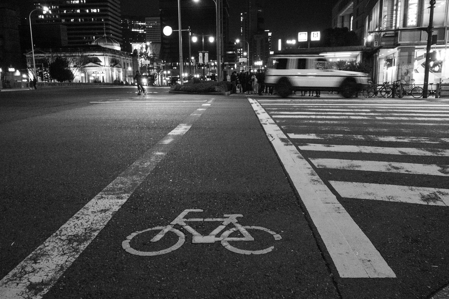 Bicycle lane symbol on a crosswalk at night in an urban setting