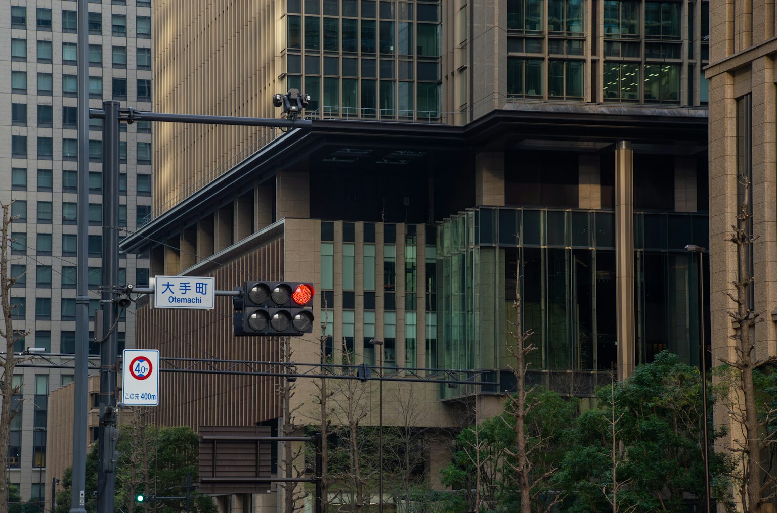 Pojok gedung modern dengan lampu lalu lintas dan pemandangan kota di sekitarnya
