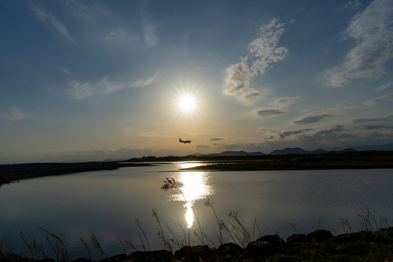 Paysage serein avec le coucher de soleil se reflétant sur l'eau avion volant dans le ciel