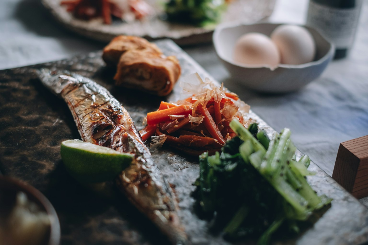 Pescado a la parrilla servido con verduras frescas y lima