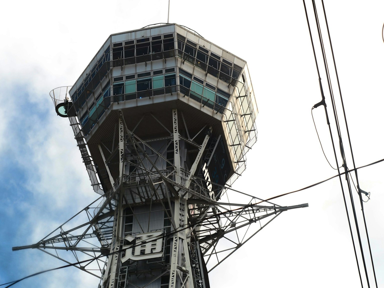 Struktur atas Menara Tsutenkaku di Osaka dengan langit biru
