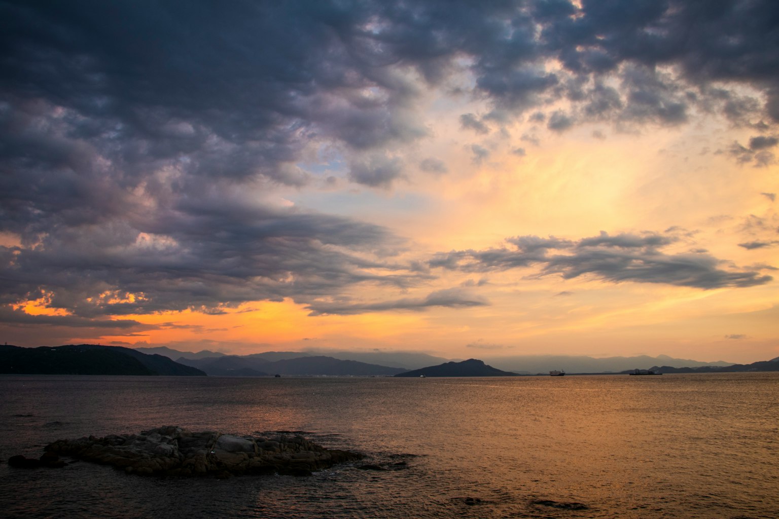 Schöner Sonnenuntergang über dem Meer dunkle Wolken und orangefarbener Himmel