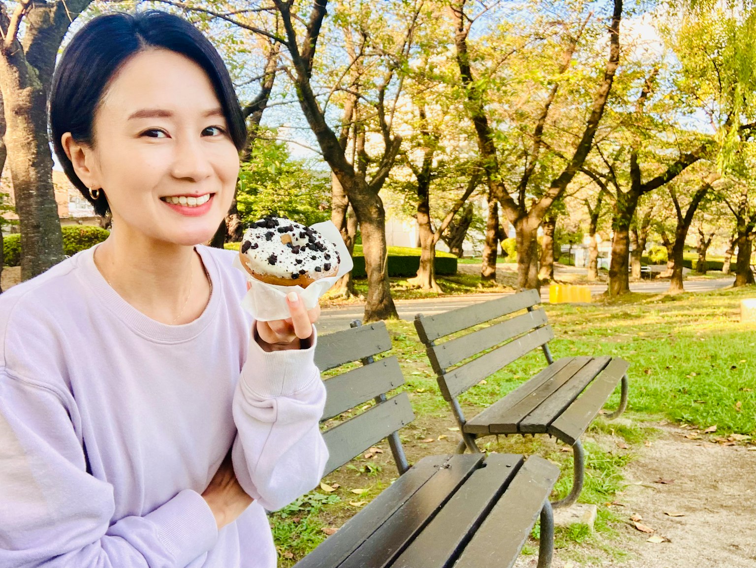 在公園裡微笑著拿著甜點的女人