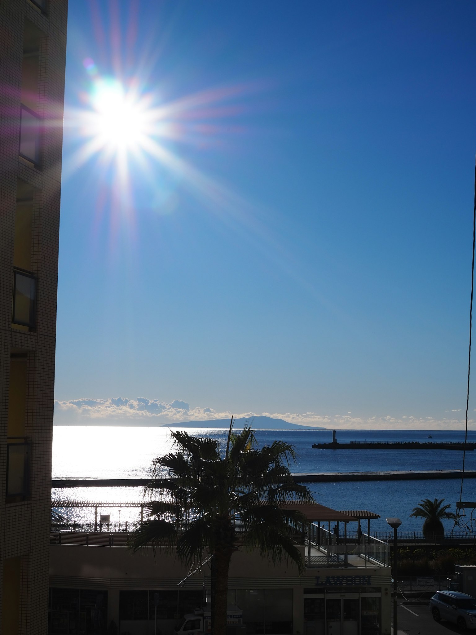 Helle Sonne über einem ruhigen Meer mit Palmen