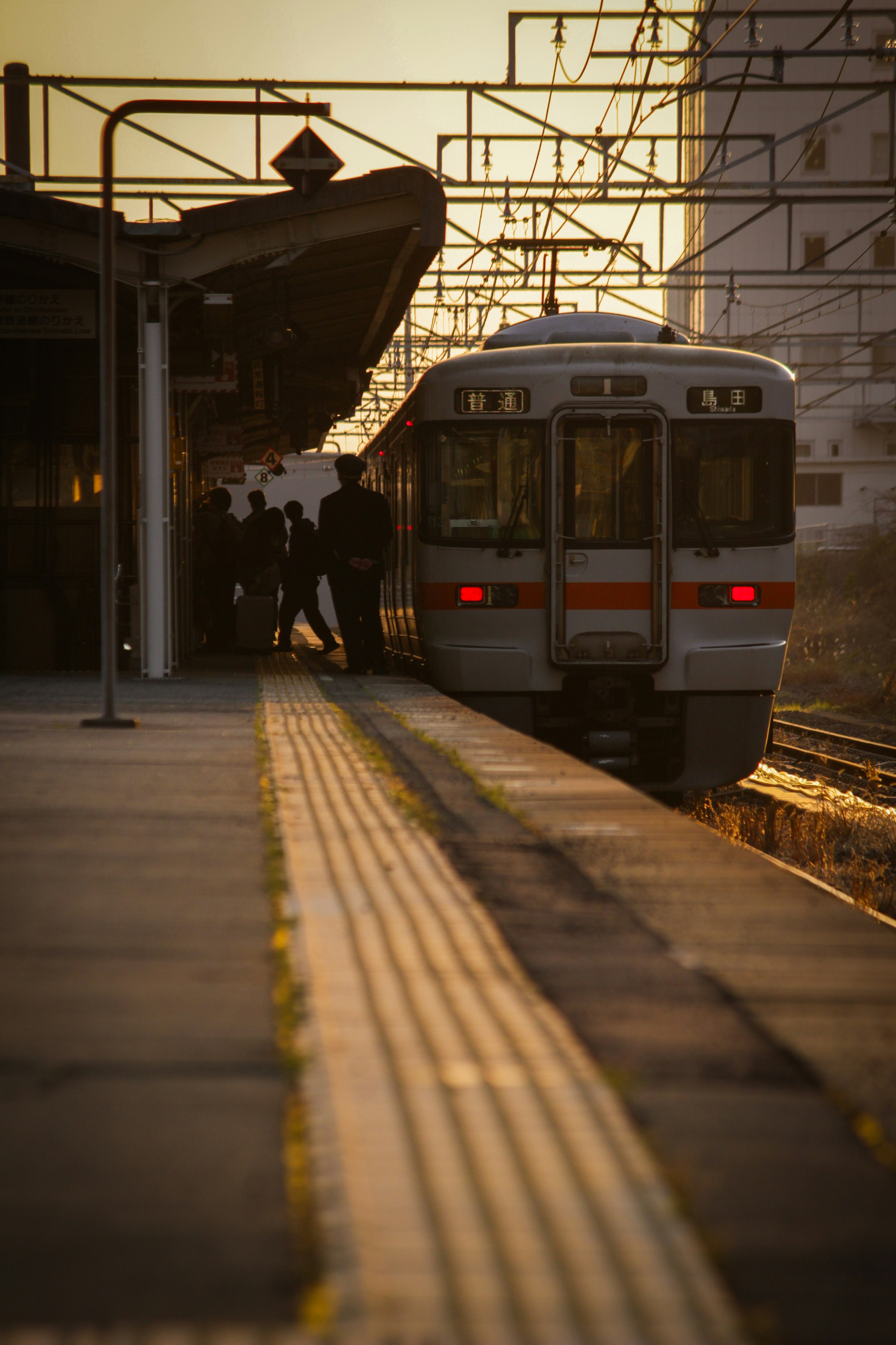 夕方の駅ホームで走る電車のある風景