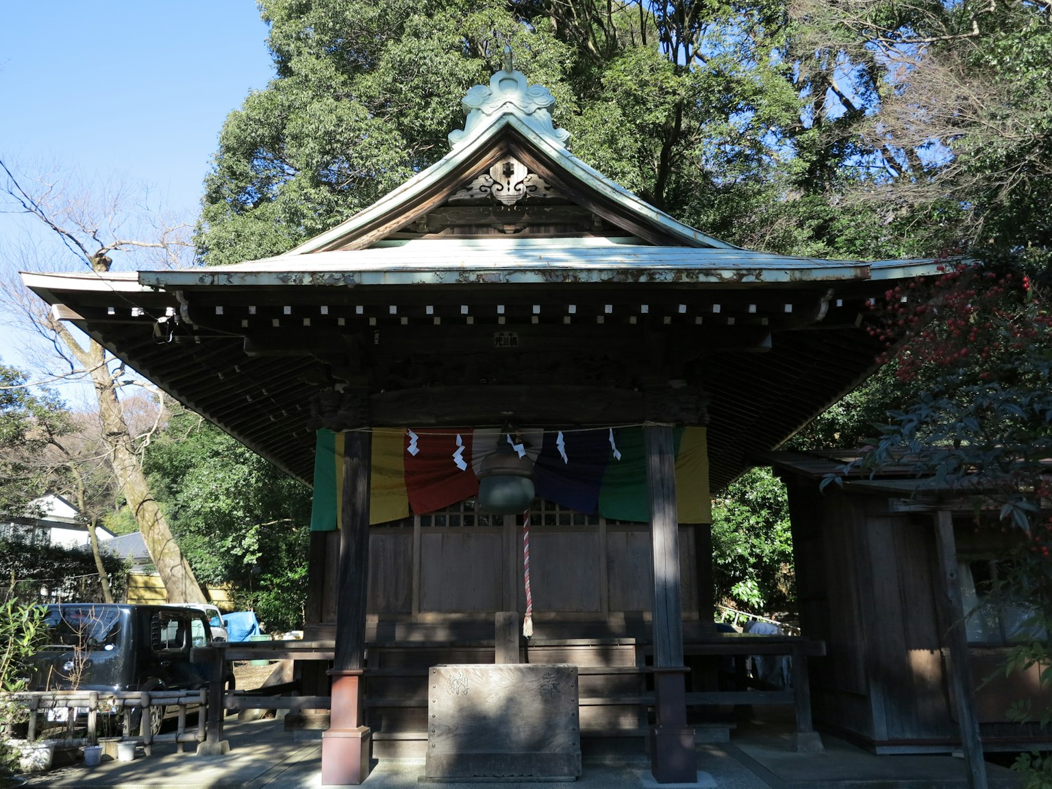 Old shrine building with green trees in the background
