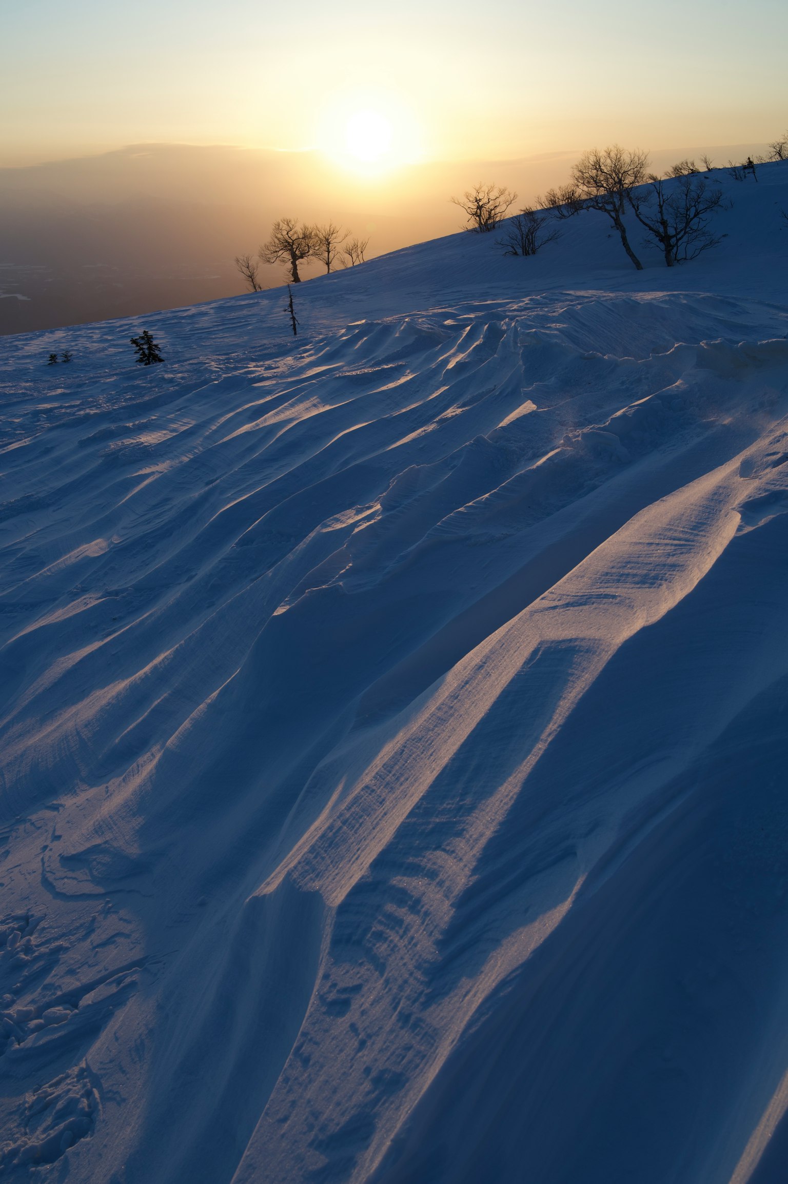 Schneebedeckte Hügellandschaft mit einem schönen Sonnenuntergang