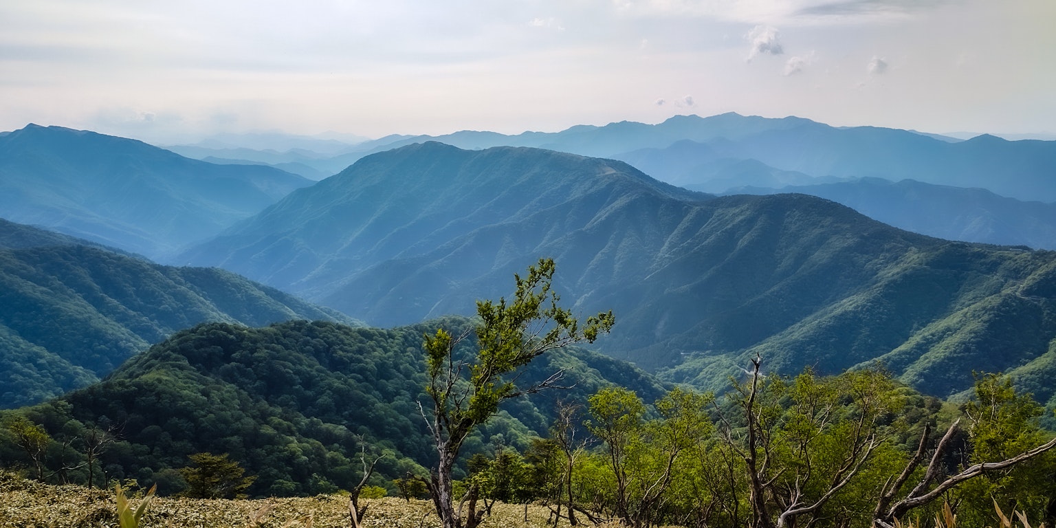 Scenic view of green mountains under a blue sky
