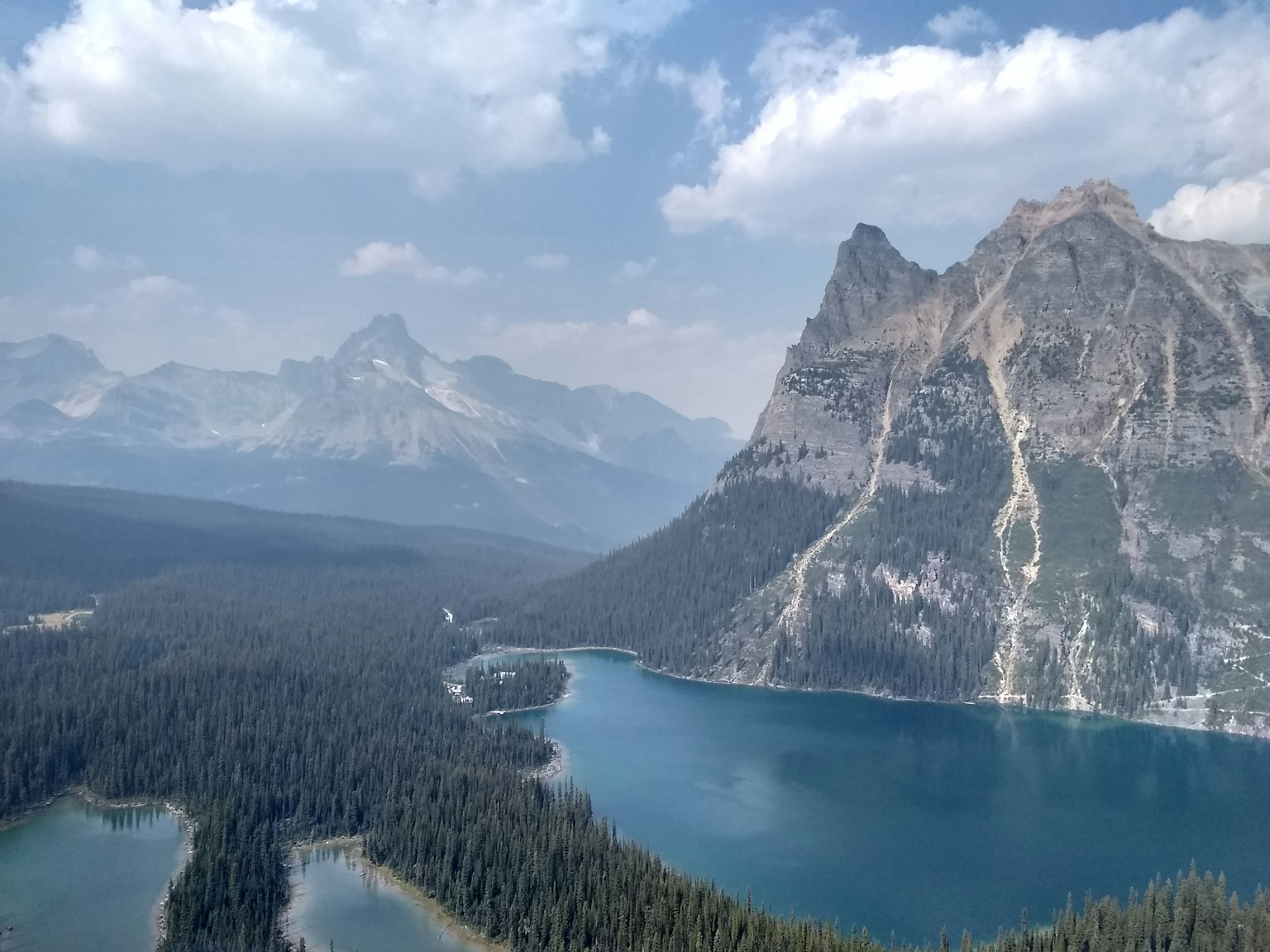 Vista escénica de un lago rodeado de montañas y bosques