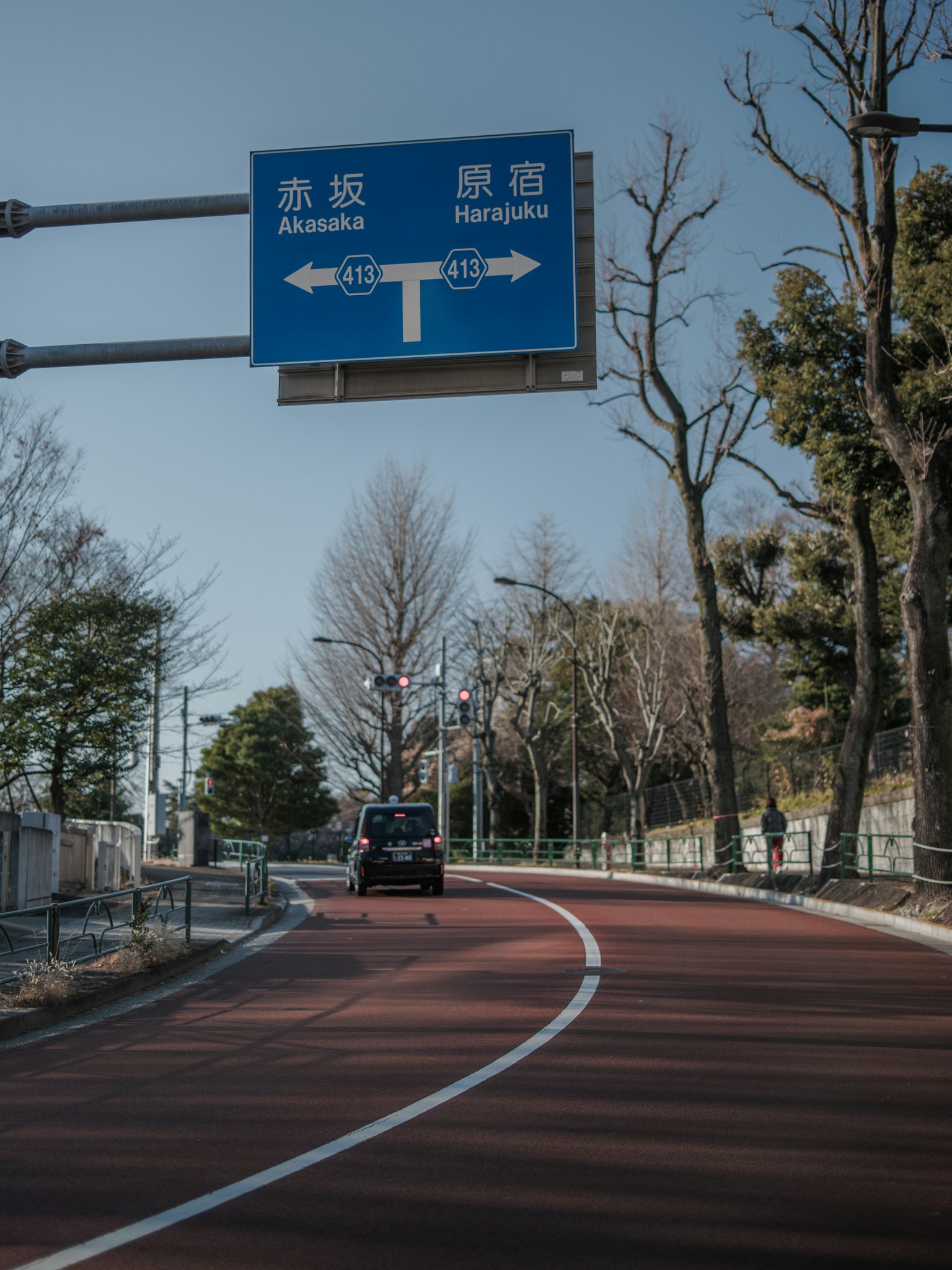 彎曲的紅色道路和方向交通標誌