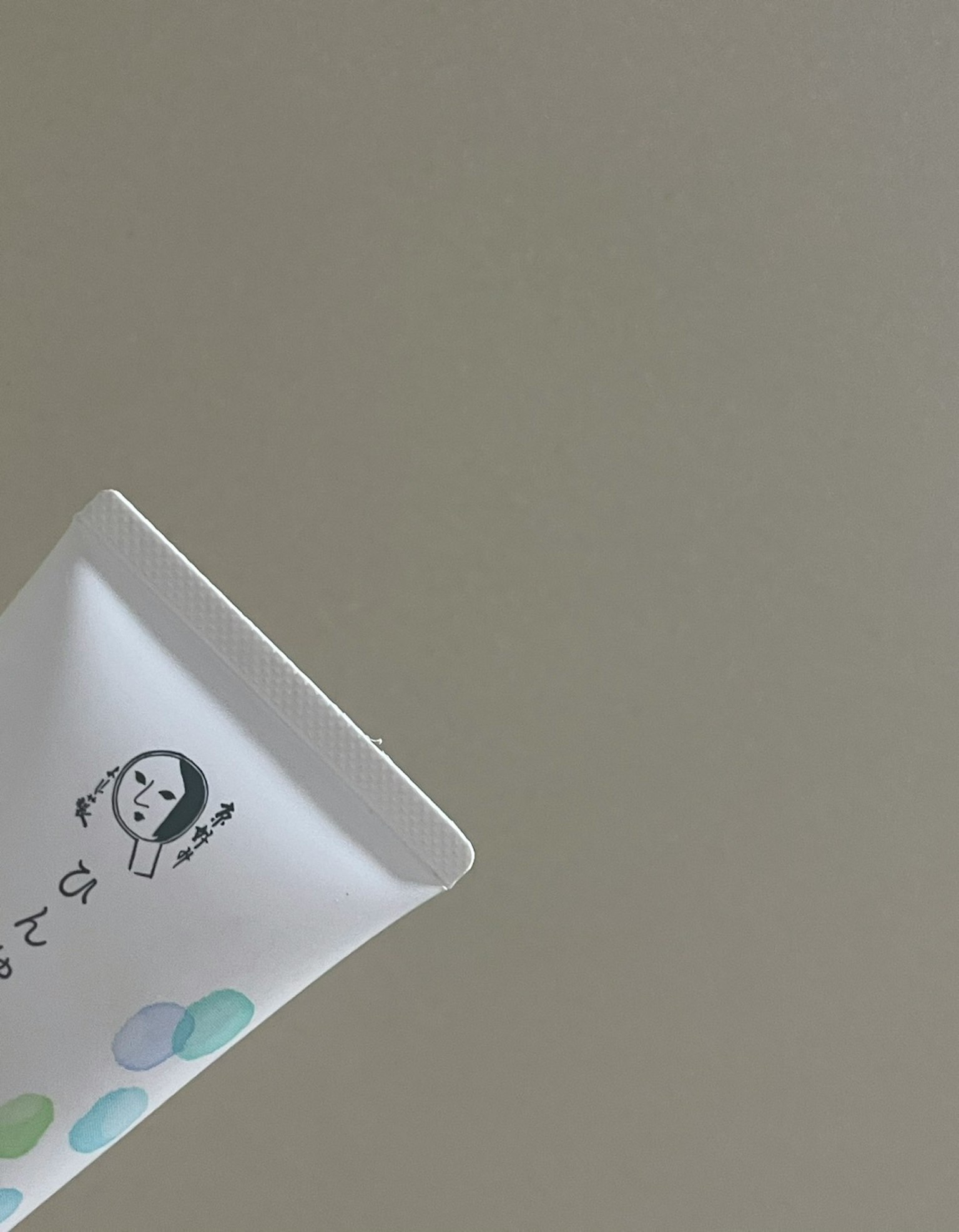 Tubetto bianco di prodotto per la cura della pelle con design a pois colorati
