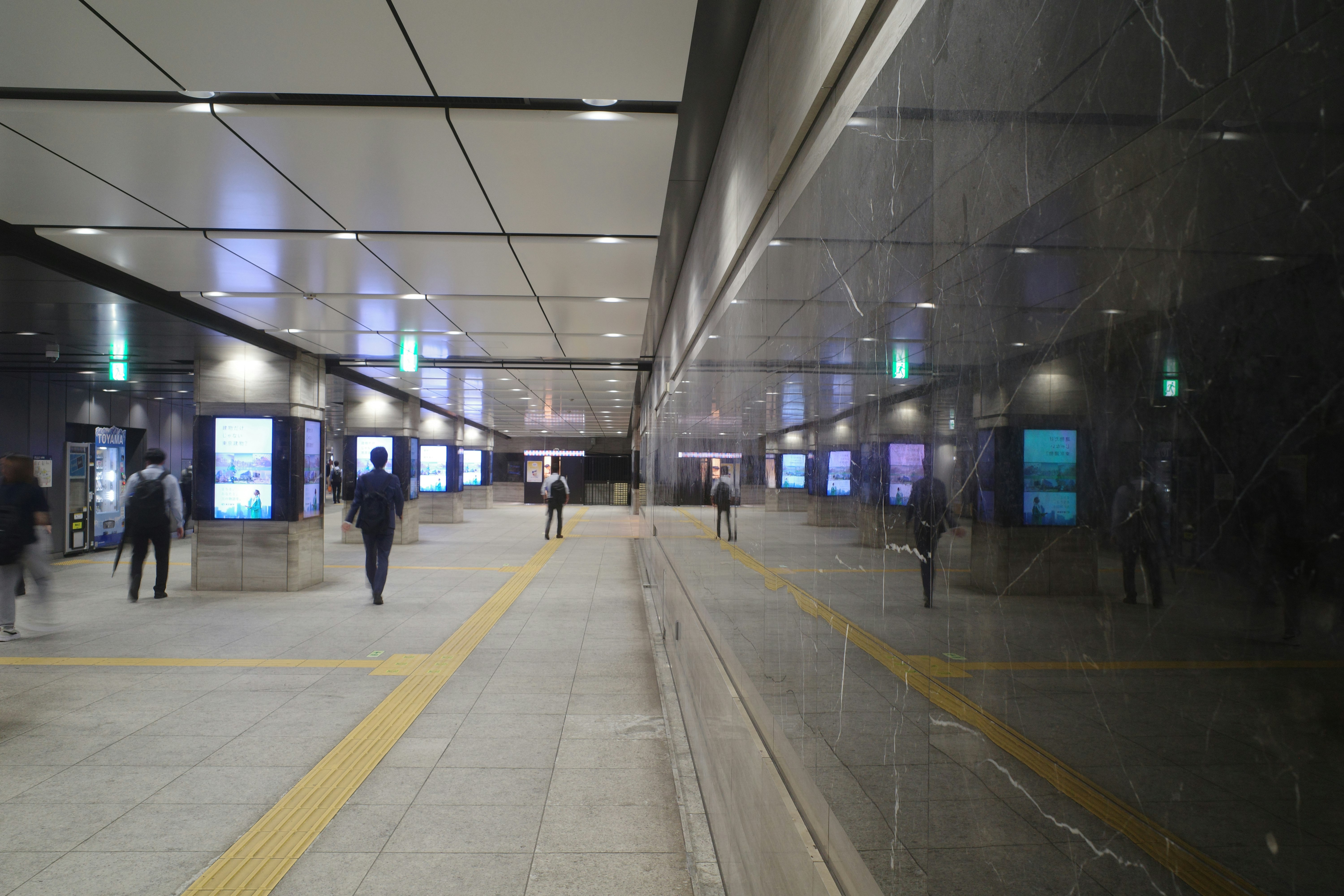 駅のホームで人が行き交う通路の風景