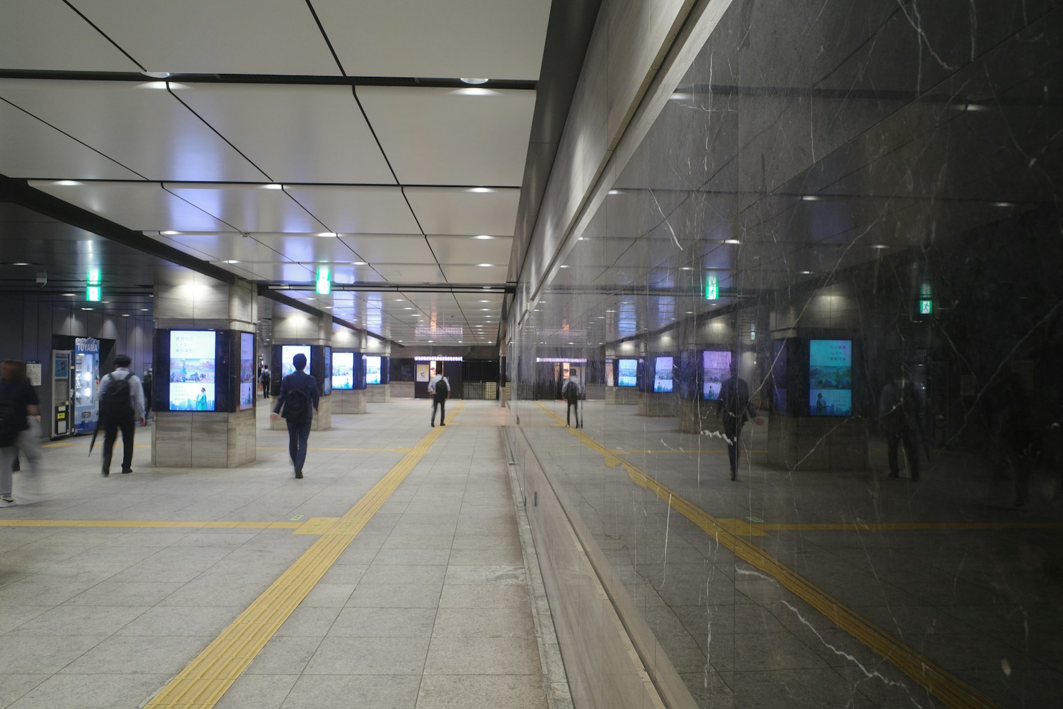 Lorong bawah tanah modern orang-orang berjalan dinding reflektif dan pencahayaan cerah